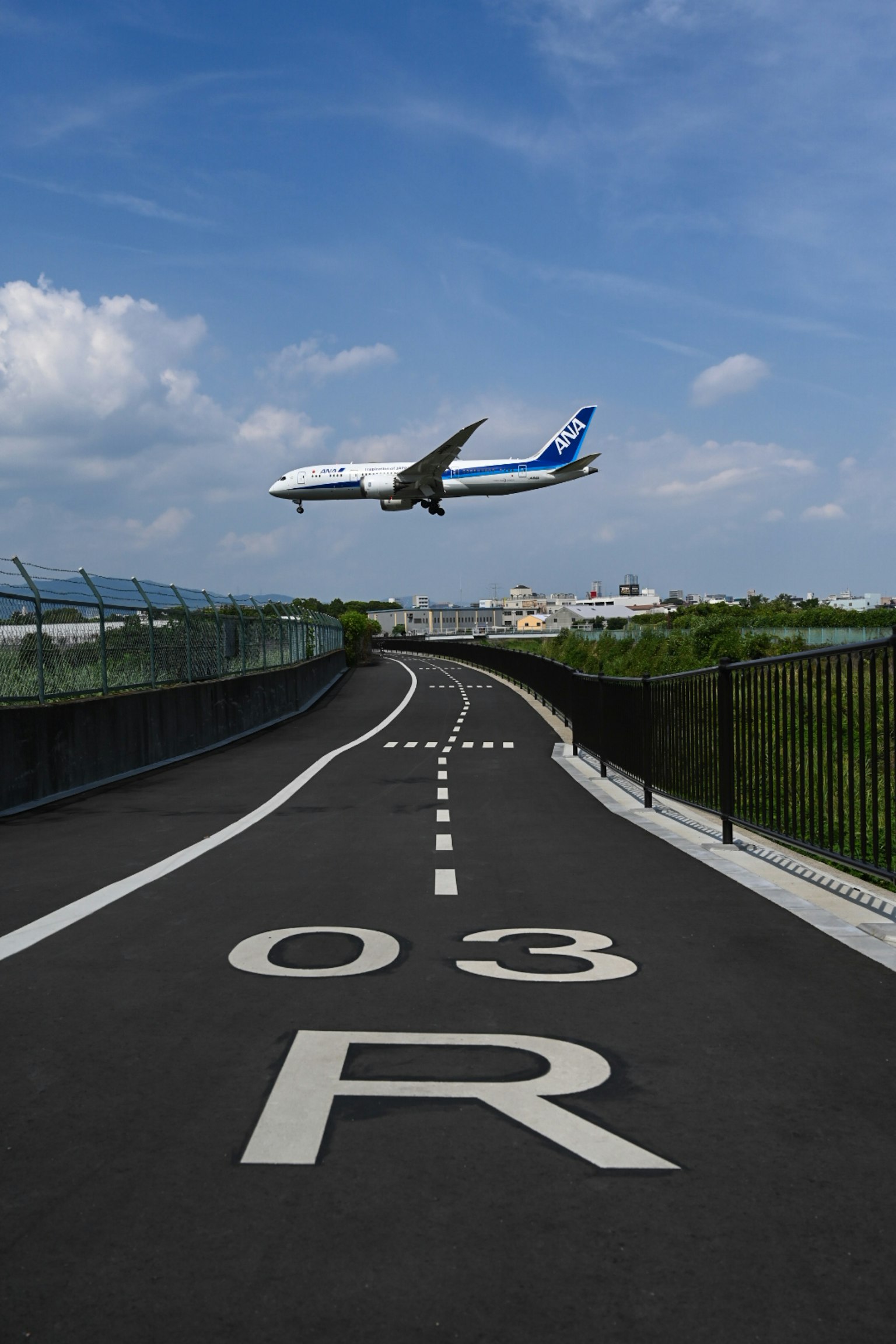 เครื่องบินบินอยู่เหนือถนนที่มีหมายเลขรันเวย์ 03R