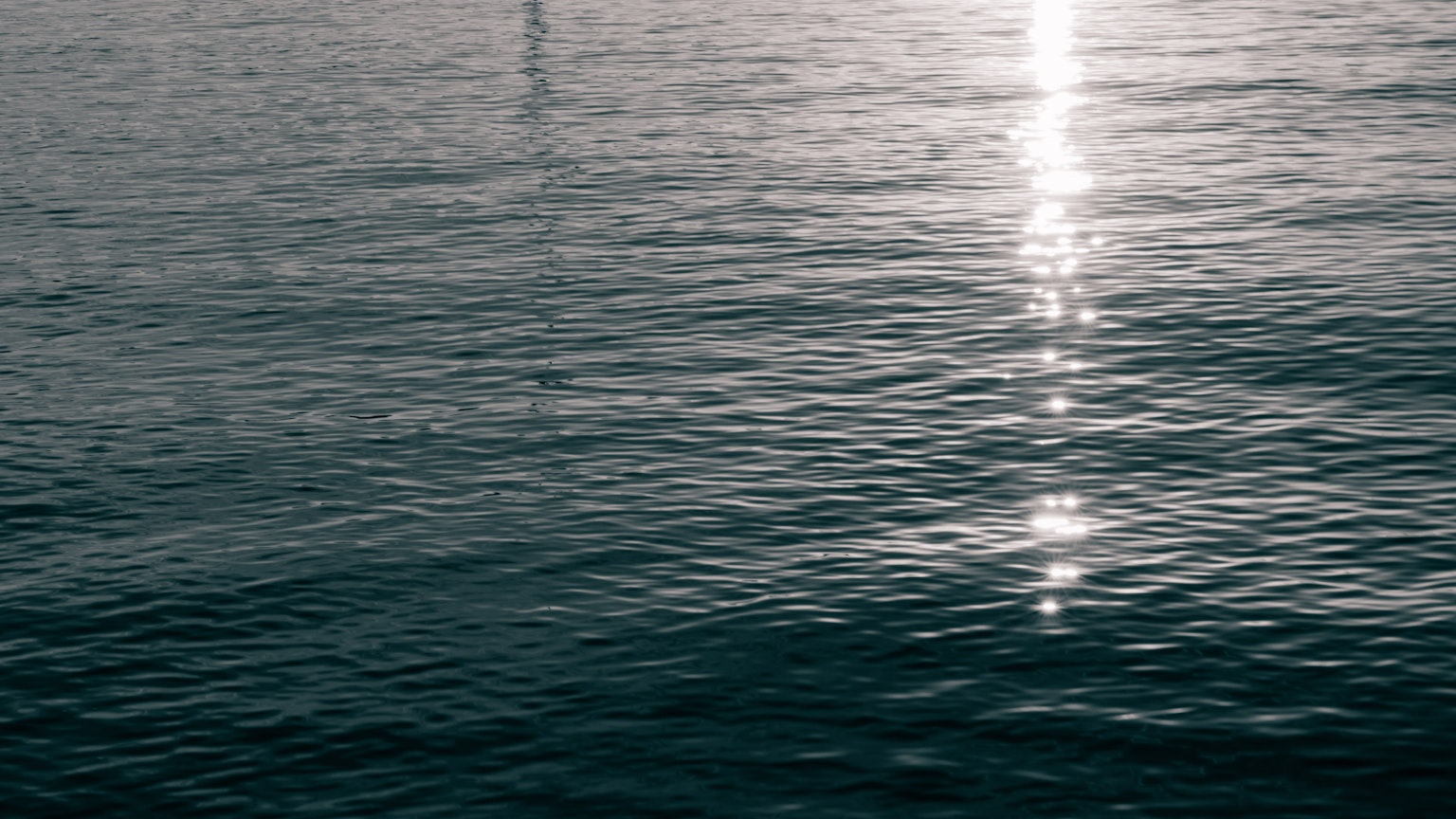 Superficie de agua tranquila reflejando una hermosa luz
