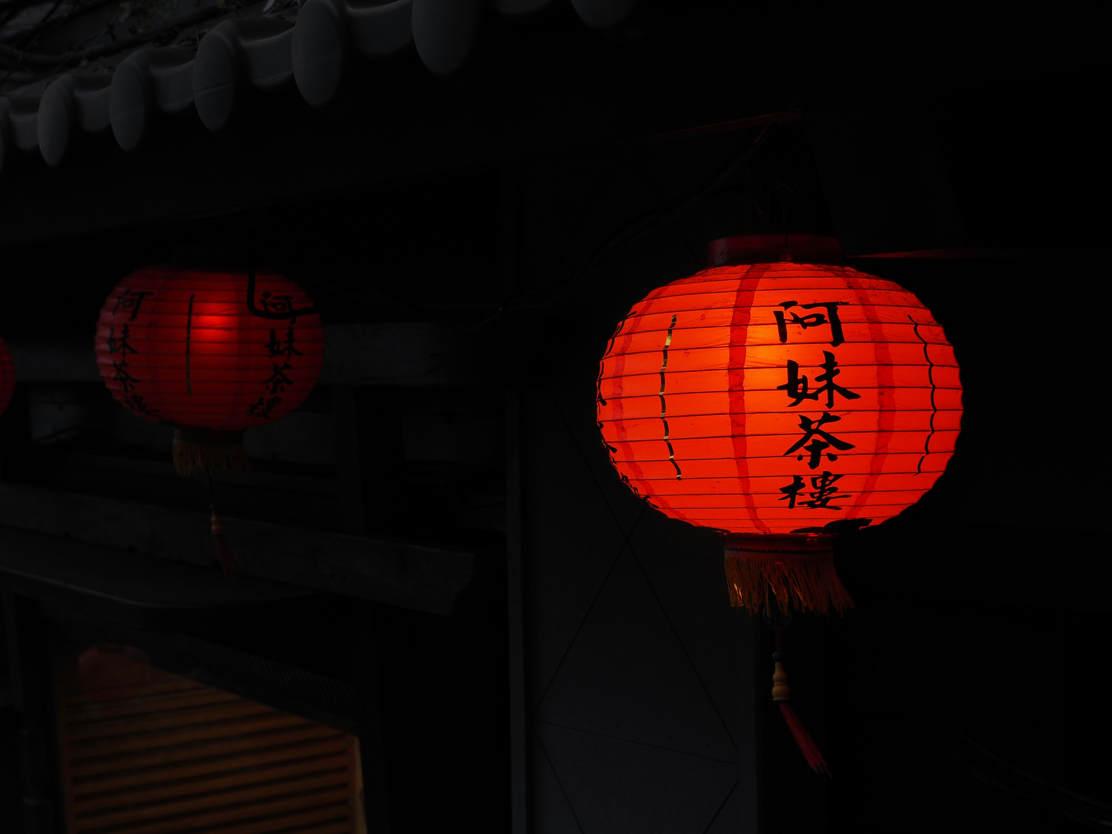 夜晚小吃攤街道屋簷下寫有中文的燈籠