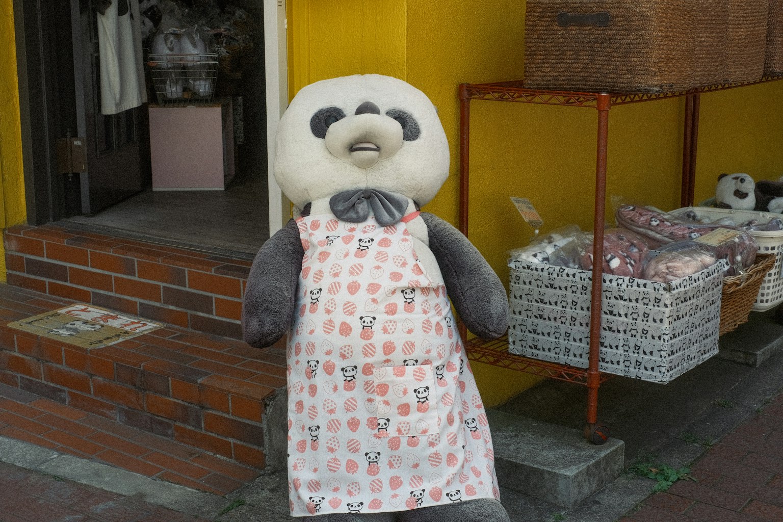 穿着围裙的熊猫吉祥物站在商店外面