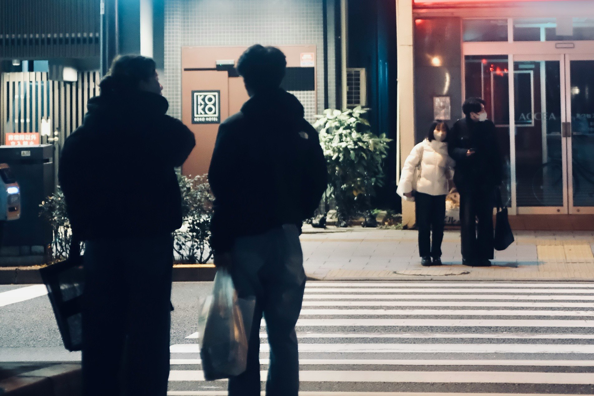 silhouettes of people walking across a crosswalk in the city