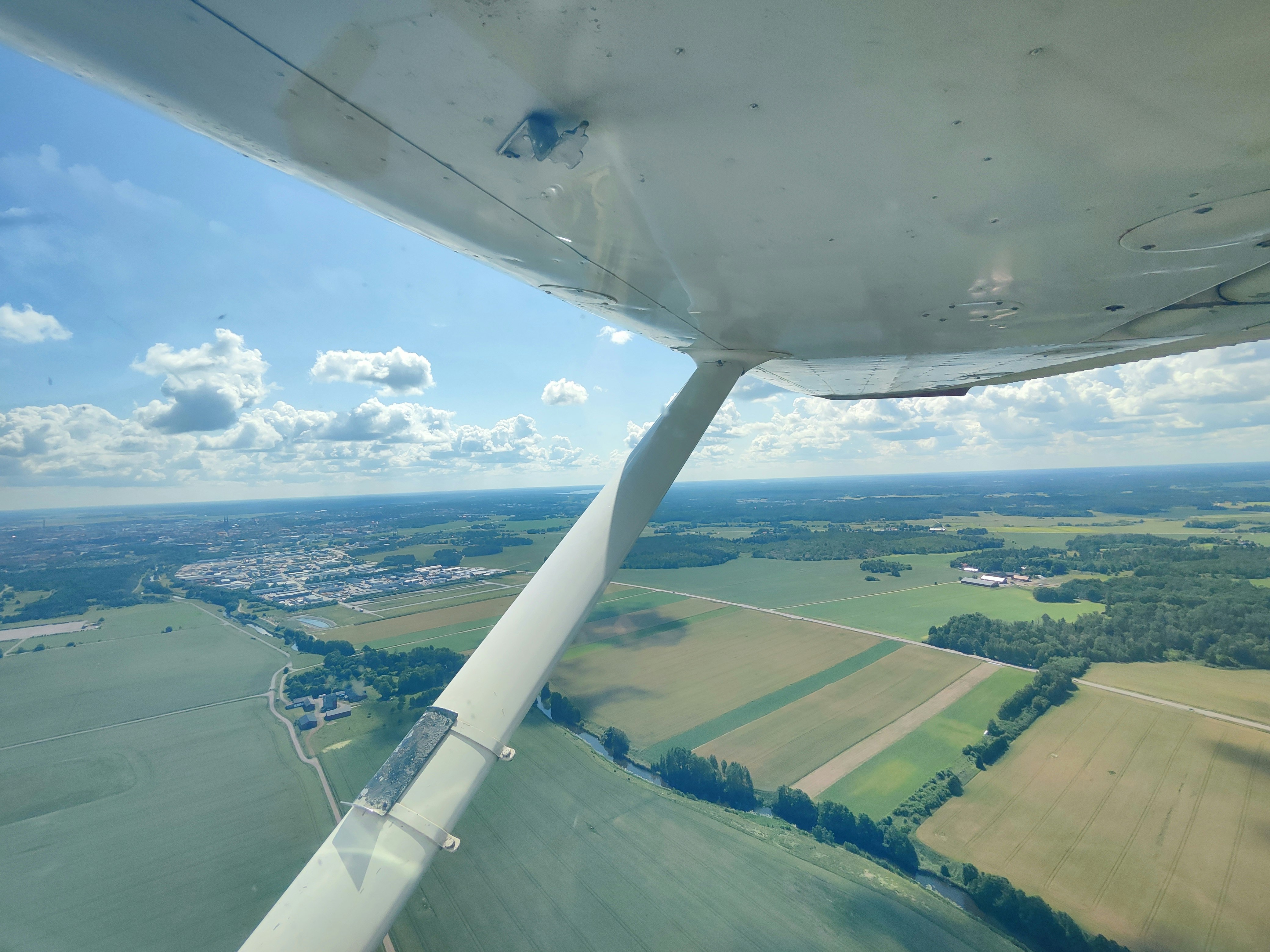 Luftaufnahme von Fluss und Feldern vom Flugzeugfenster aus