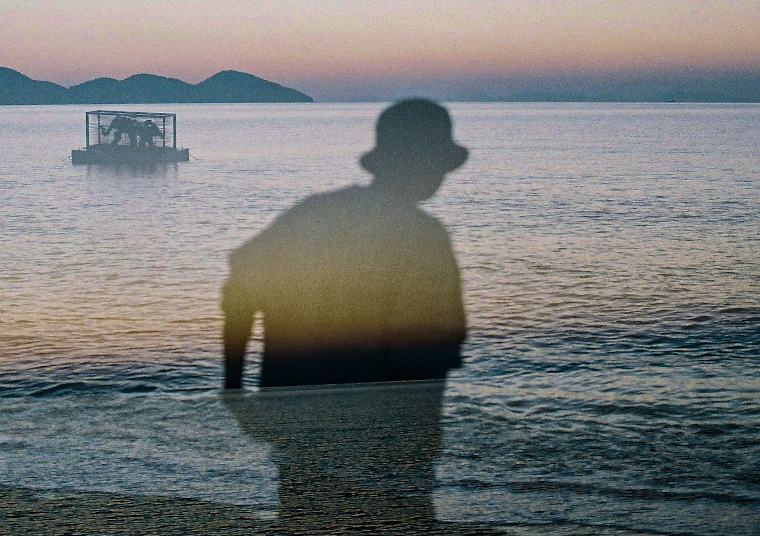 Persona con sombra en la playa durante un atardecer tranquilo