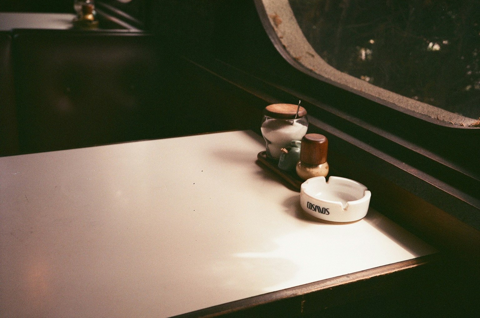Table près de la fenêtre avec une tasse de café et un cendrier