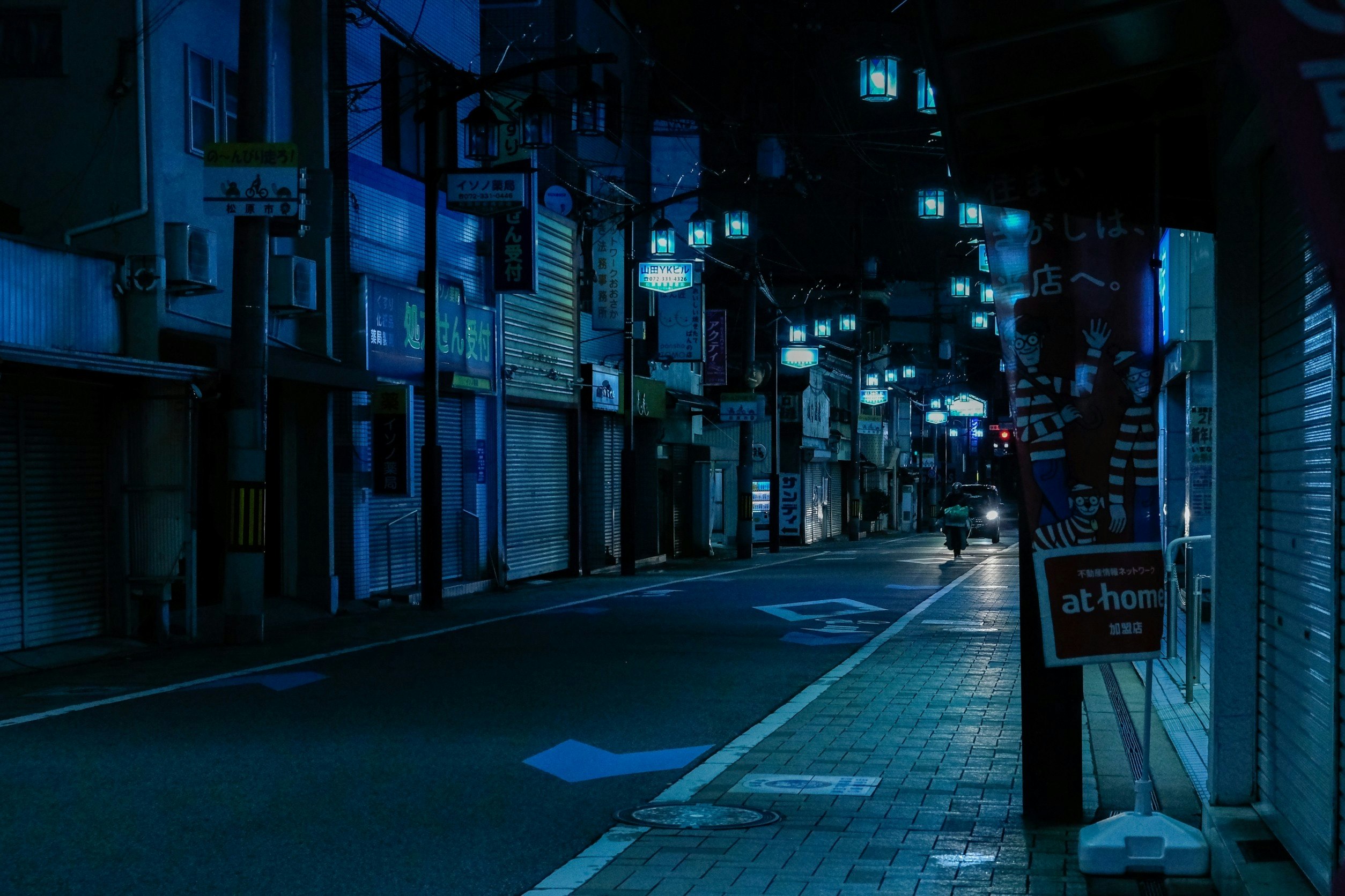 夜の路地に並ぶ店先とシャッター