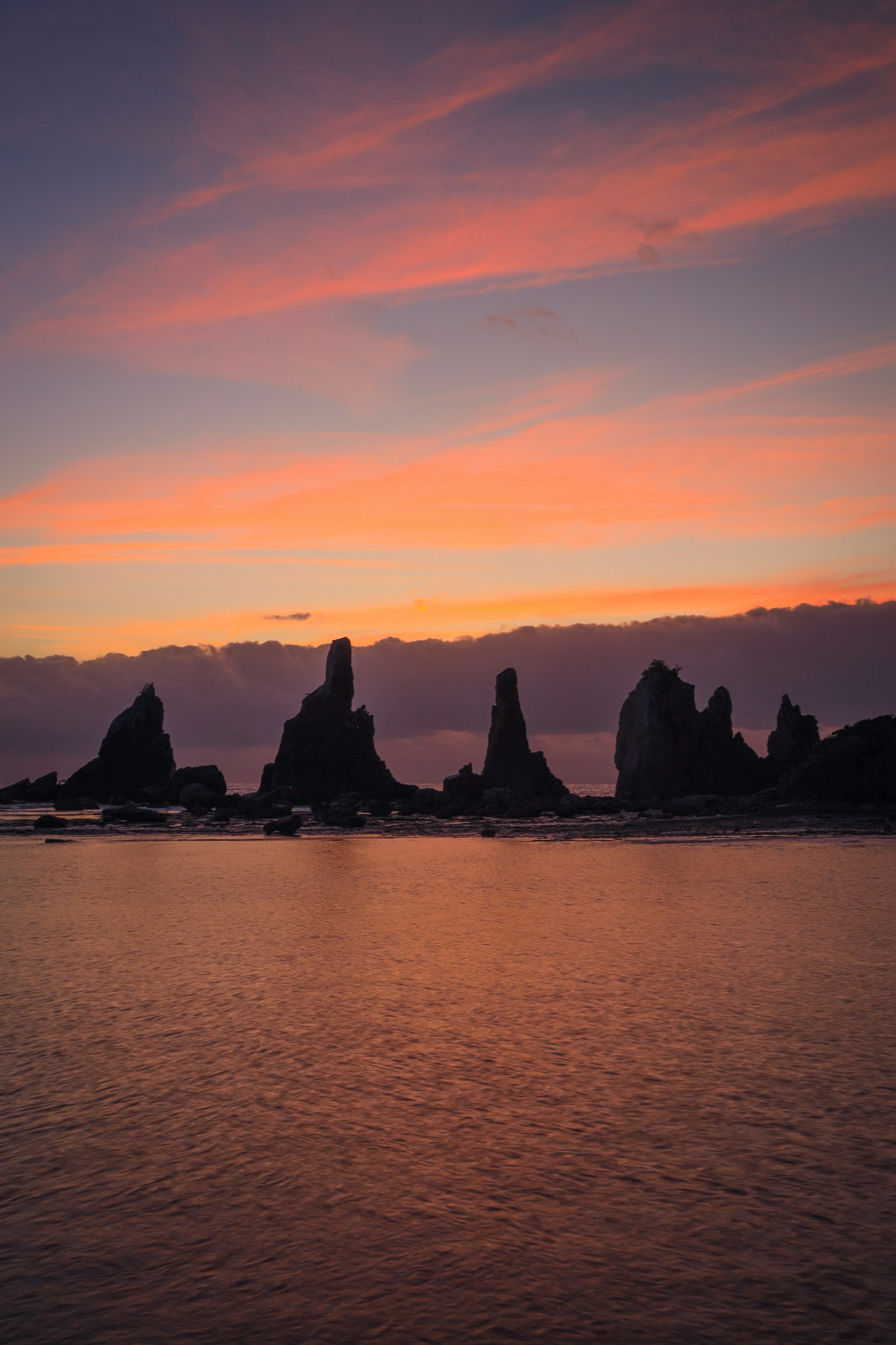 Rock formations silhouetted against a colorful sunset sky