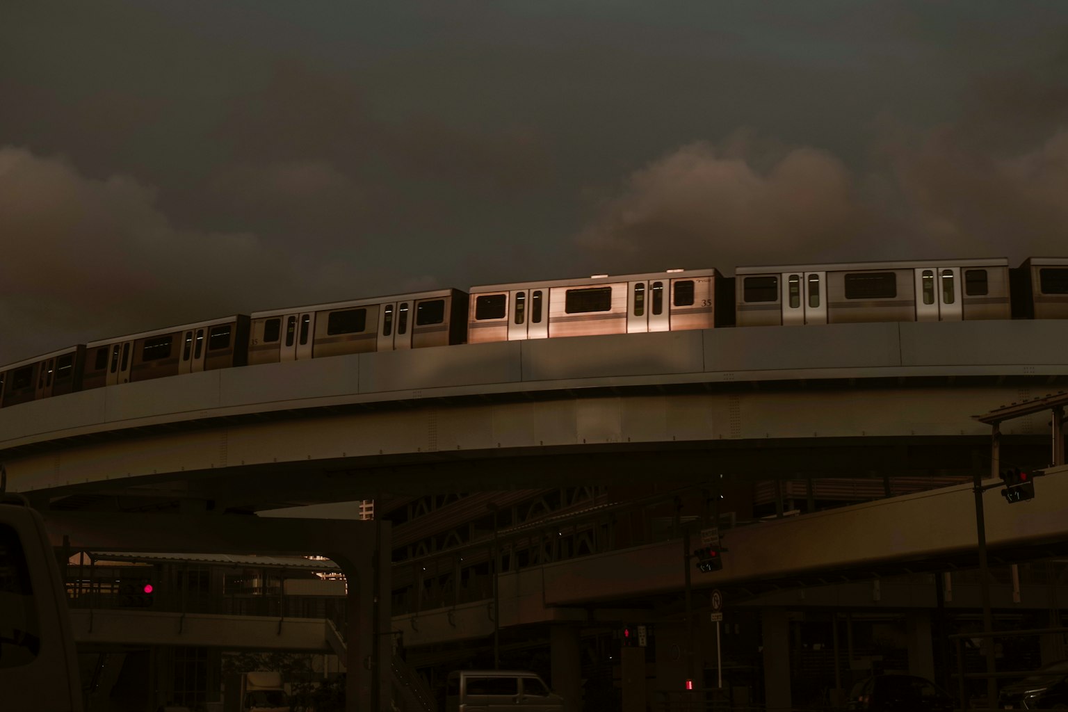 ภาพของรถไฟยกระดับที่โค้งในช่วงพลบค่ำ
