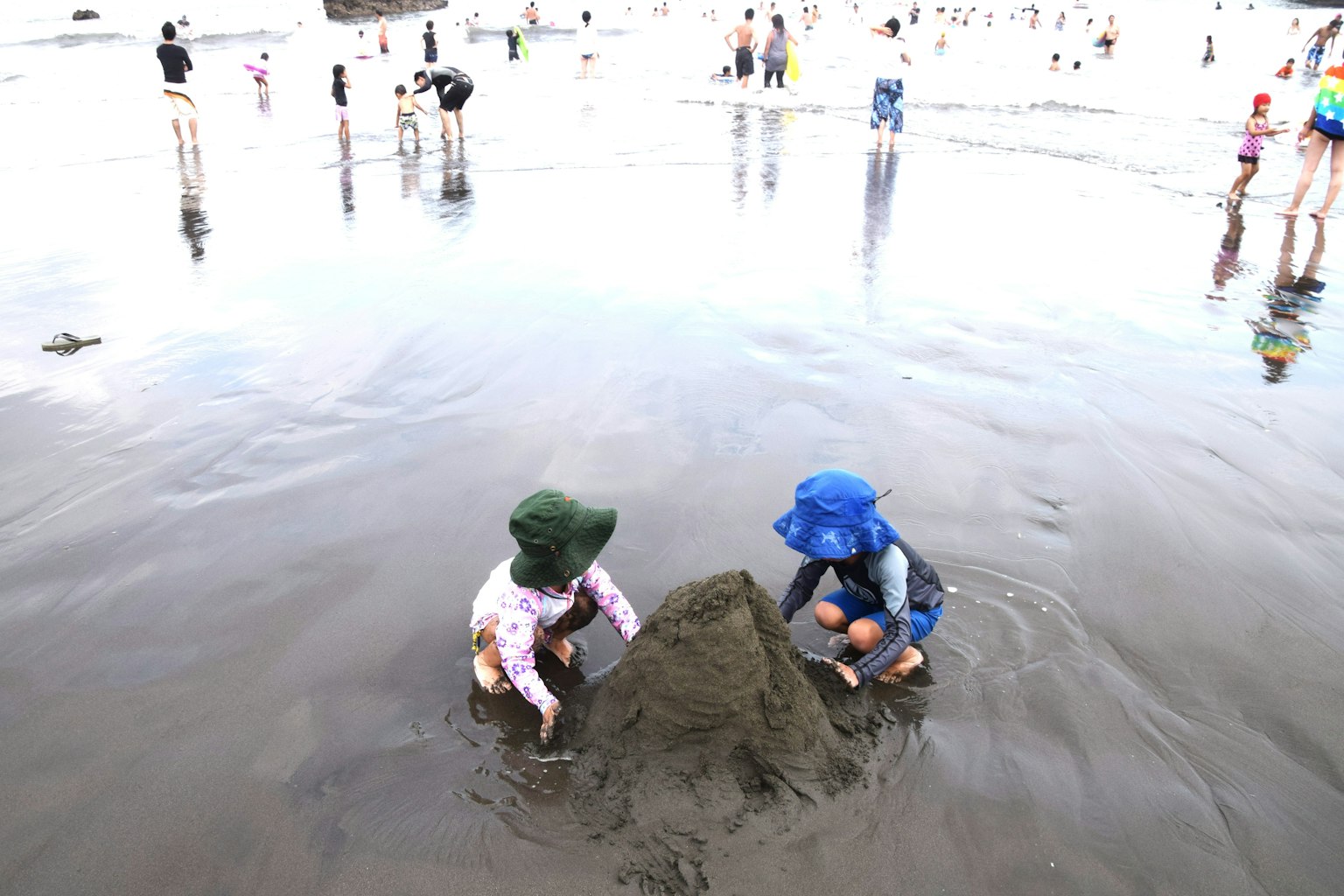 Anak-anak membangun istana pasir di pantai