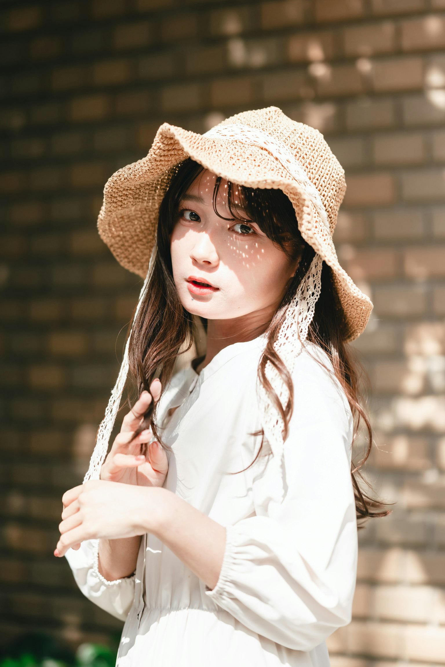 一位優雅地擺姿勢的女性戴著草帽