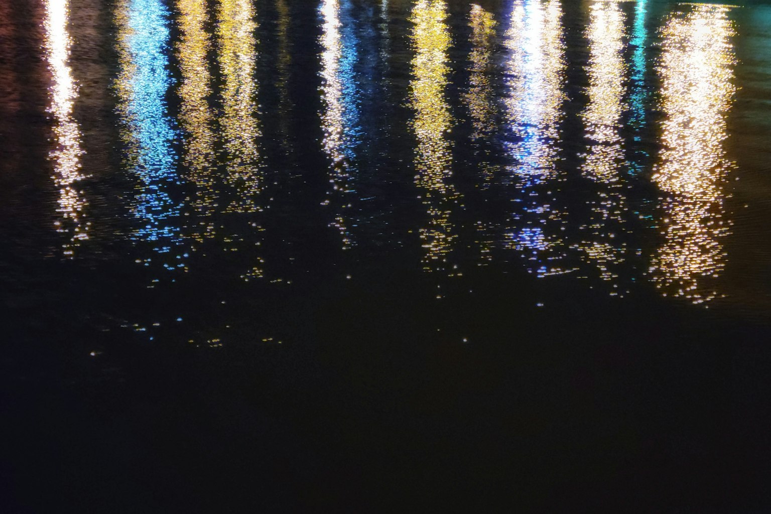 Bunte Lichtreflexionen auf der Wasseroberfläche dunkler Hintergrund