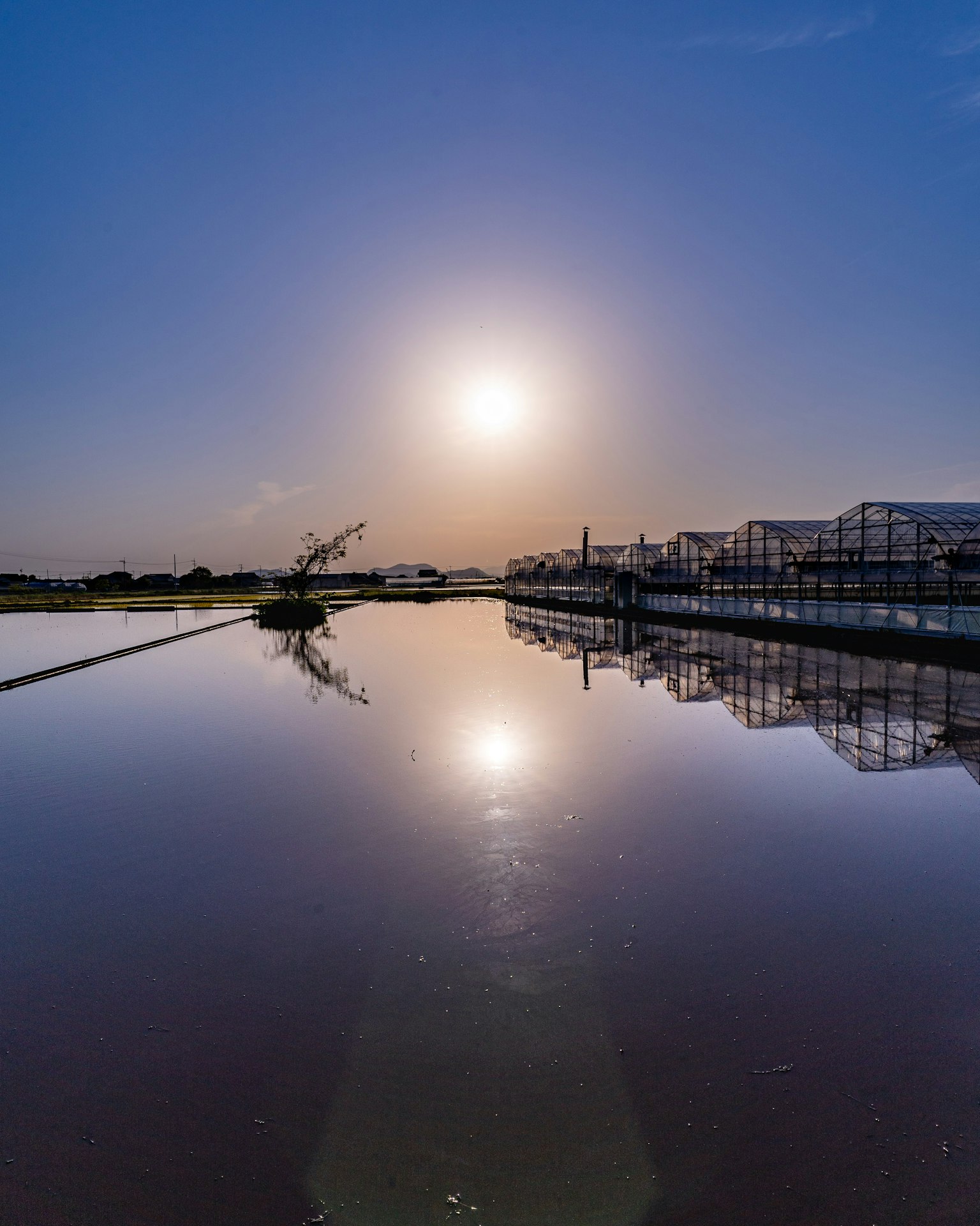 Soleil se reflétant sur l'eau calme avec paysage environnant