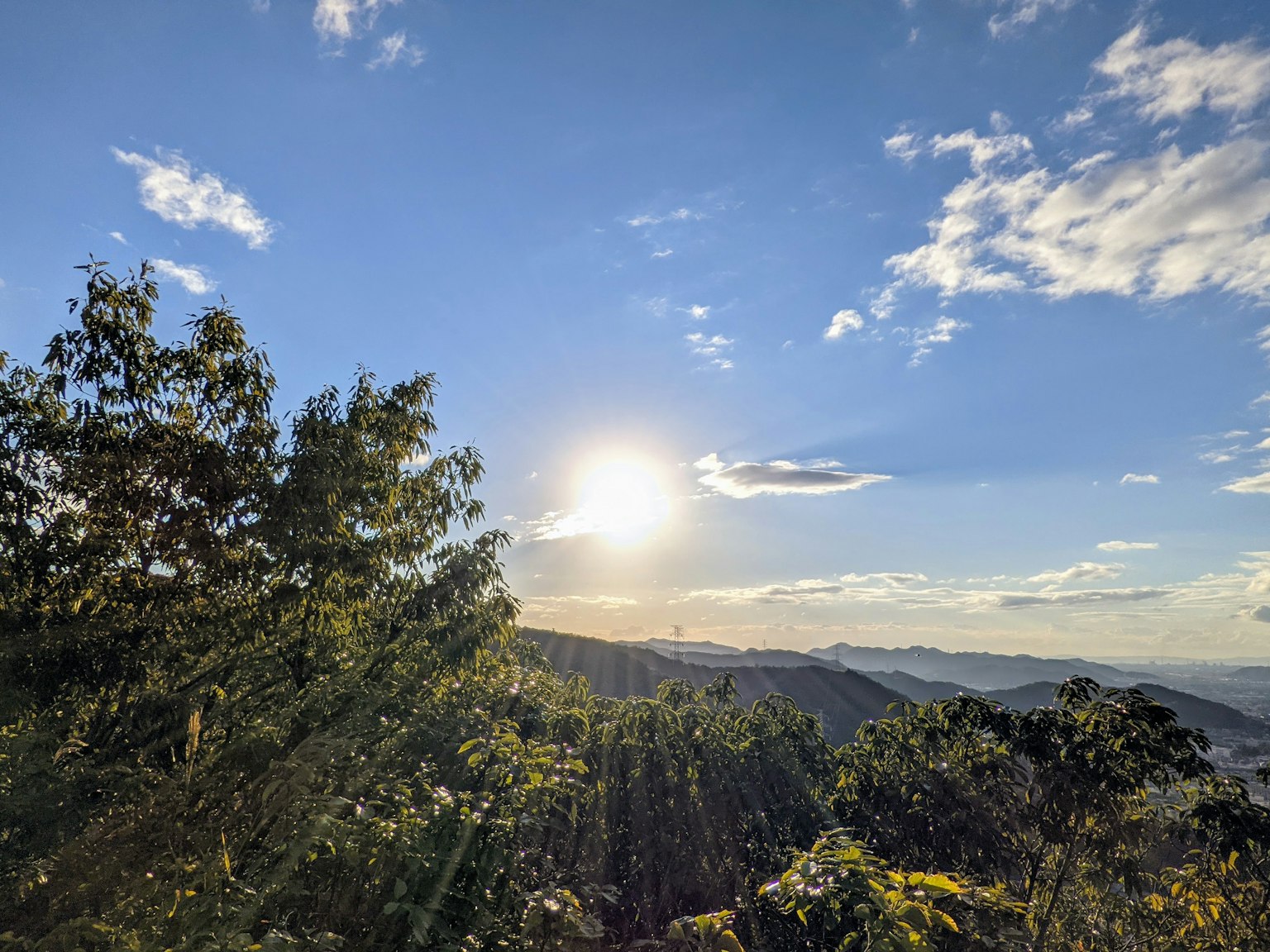 Vista panoramica delle montagne sotto un cielo azzurro con luce solare