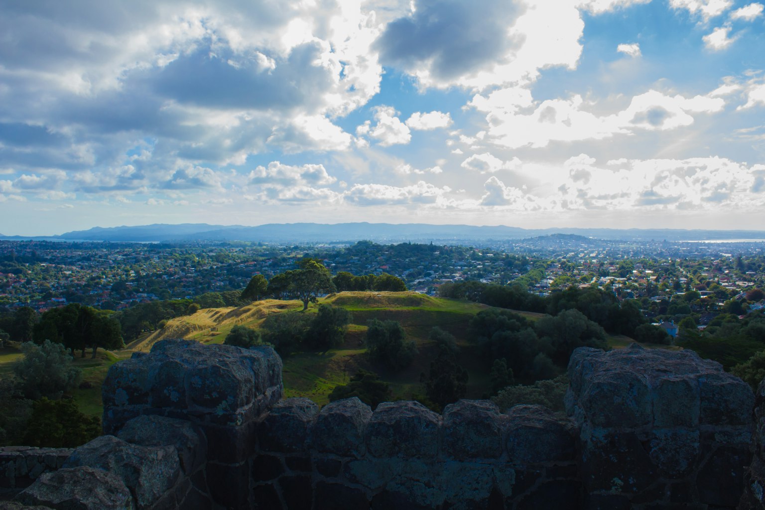 Paysage urbain avec des collines vertes et un ciel bleu