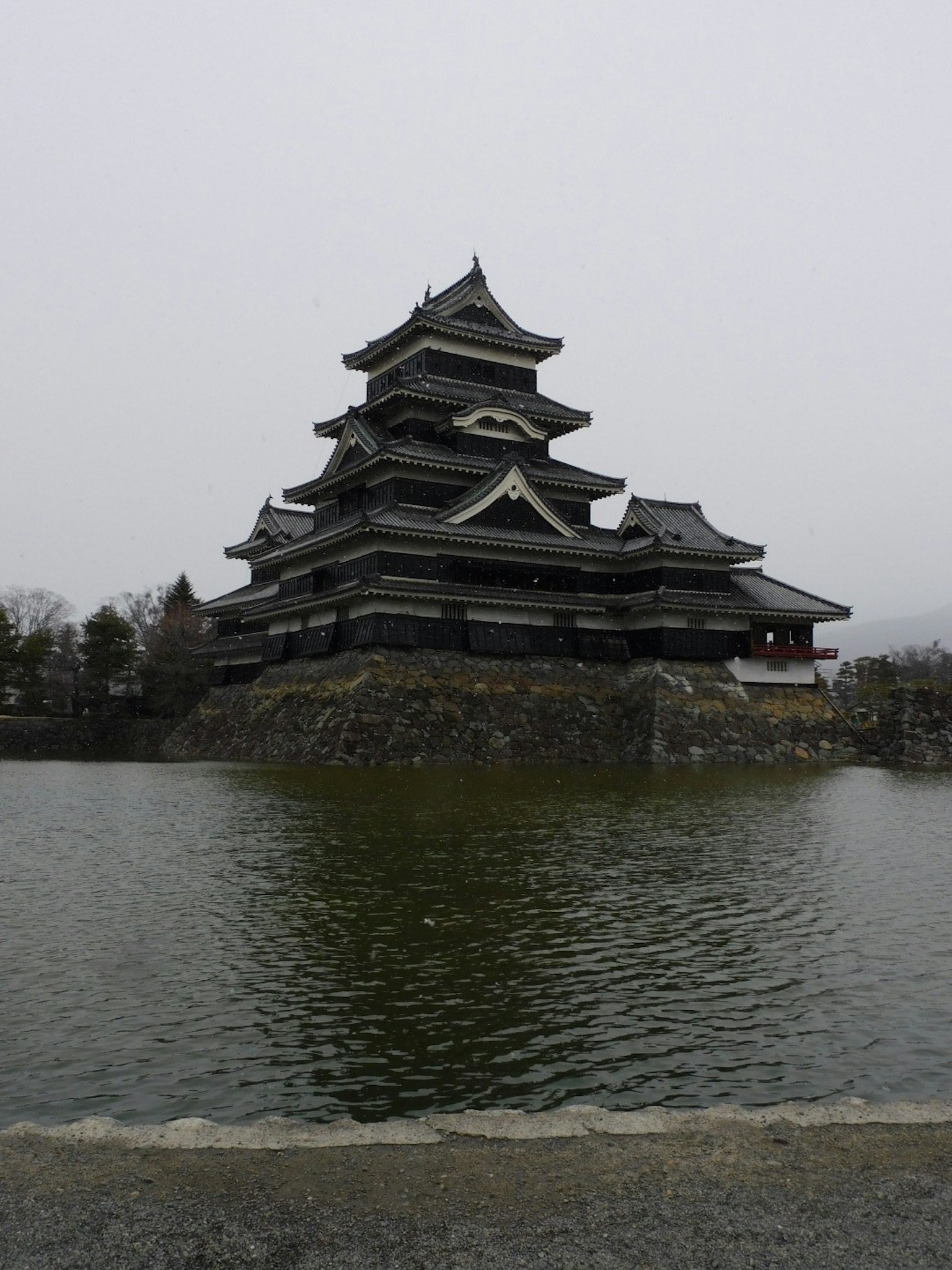 Château de Matsumoto avec un étang environnant par temps brumeux