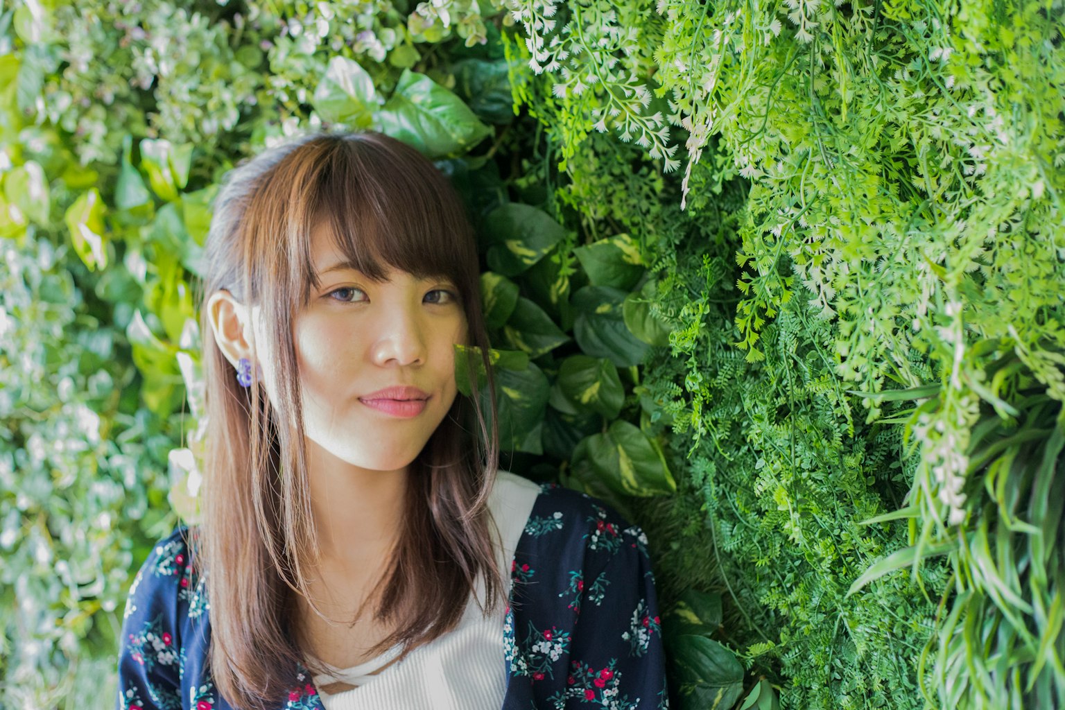 Portrait of a woman standing in front of a green wall