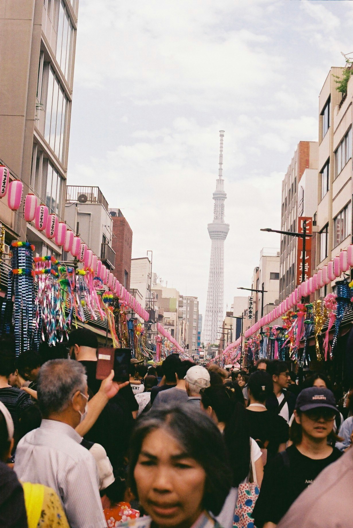 浅草寺周辺の仲見世通りで人が行き交う東京スカイツリーの見える街並み
