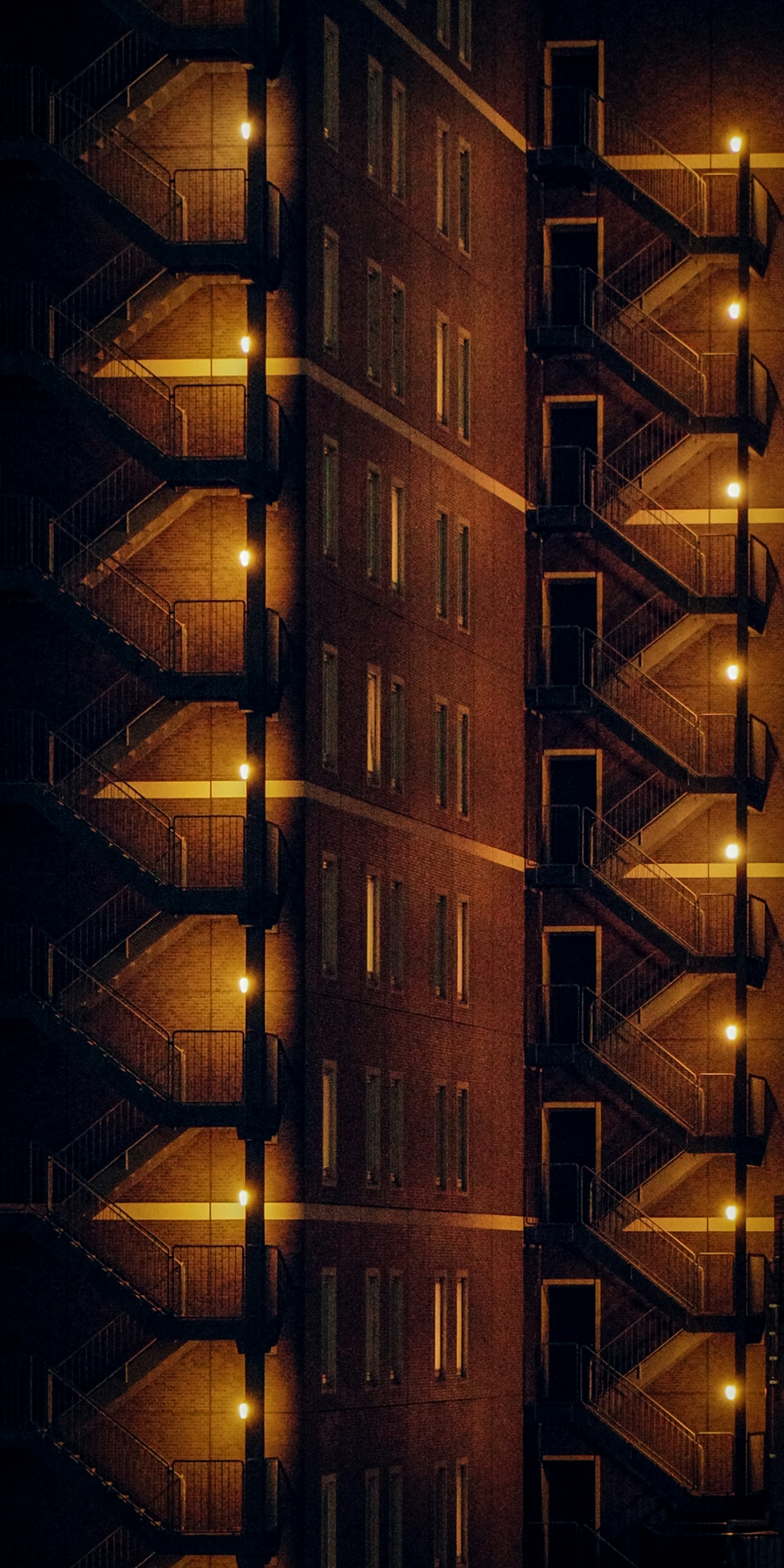 Esterno di un edificio residenziale illuminato di notte con scale e balconi