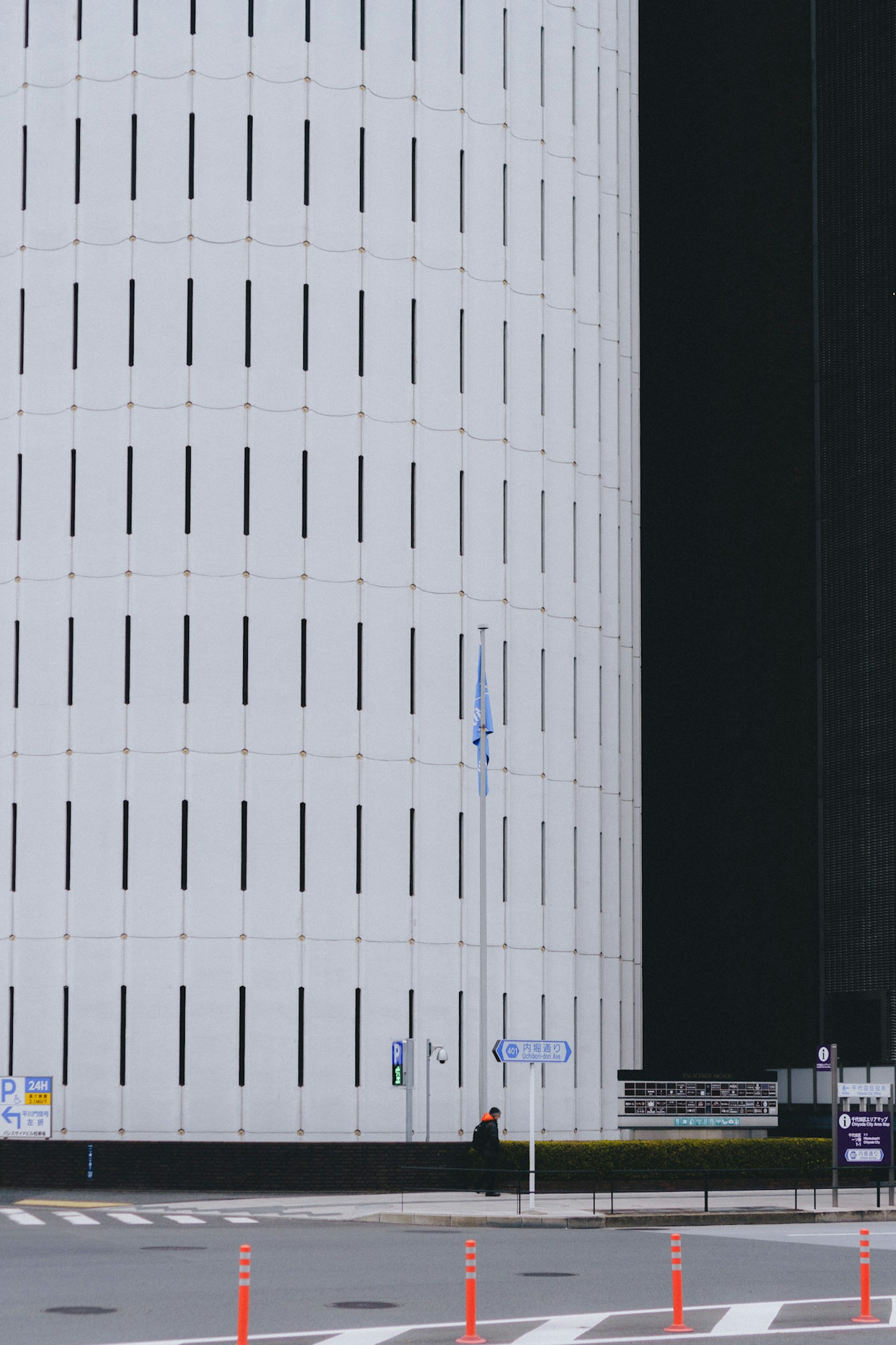 Extérieur d'un bâtiment moderne avec une structure cylindrique blanche et un mur noir contrastant