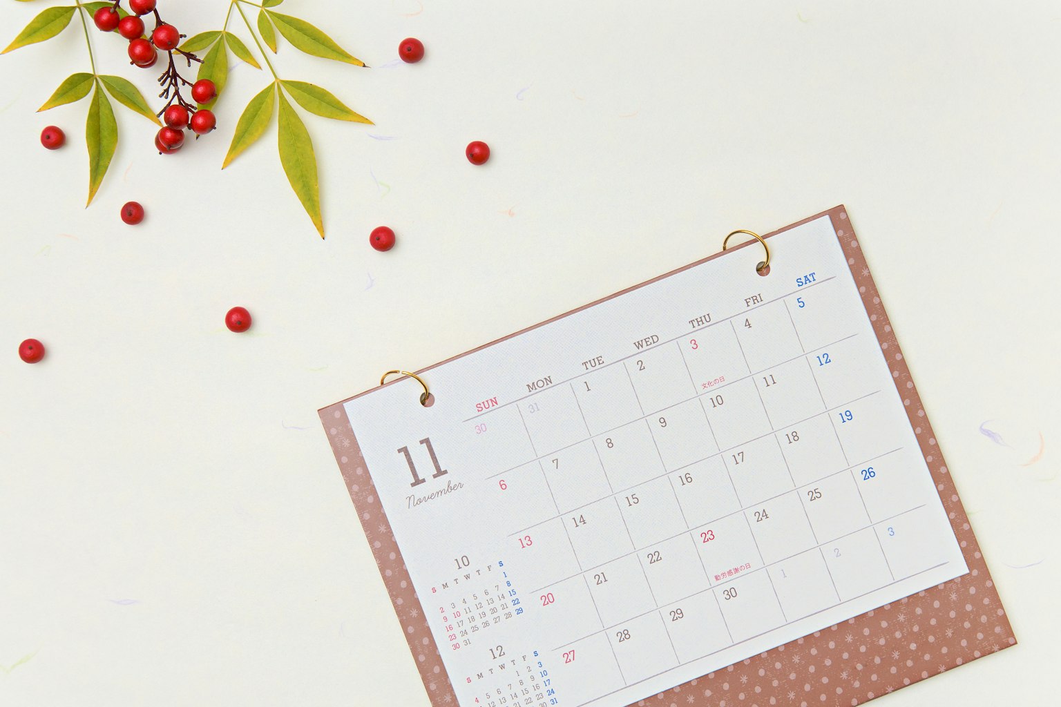 Un calendario de noviembre con bayas rojas decorativas y hojas verdes