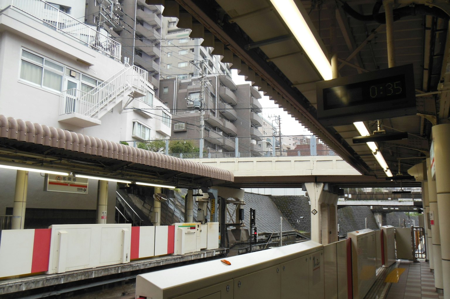 Vue d'une plateforme de gare avec des grands immeubles et des escaliers