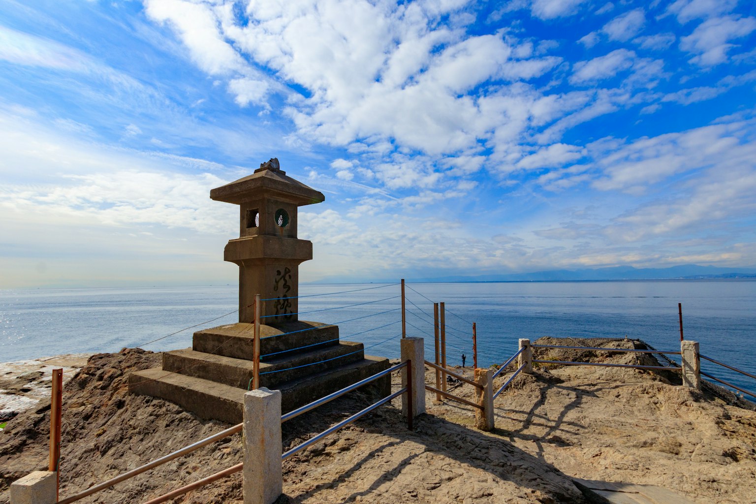 Lanterne en pierre près de la mer sous un ciel bleu