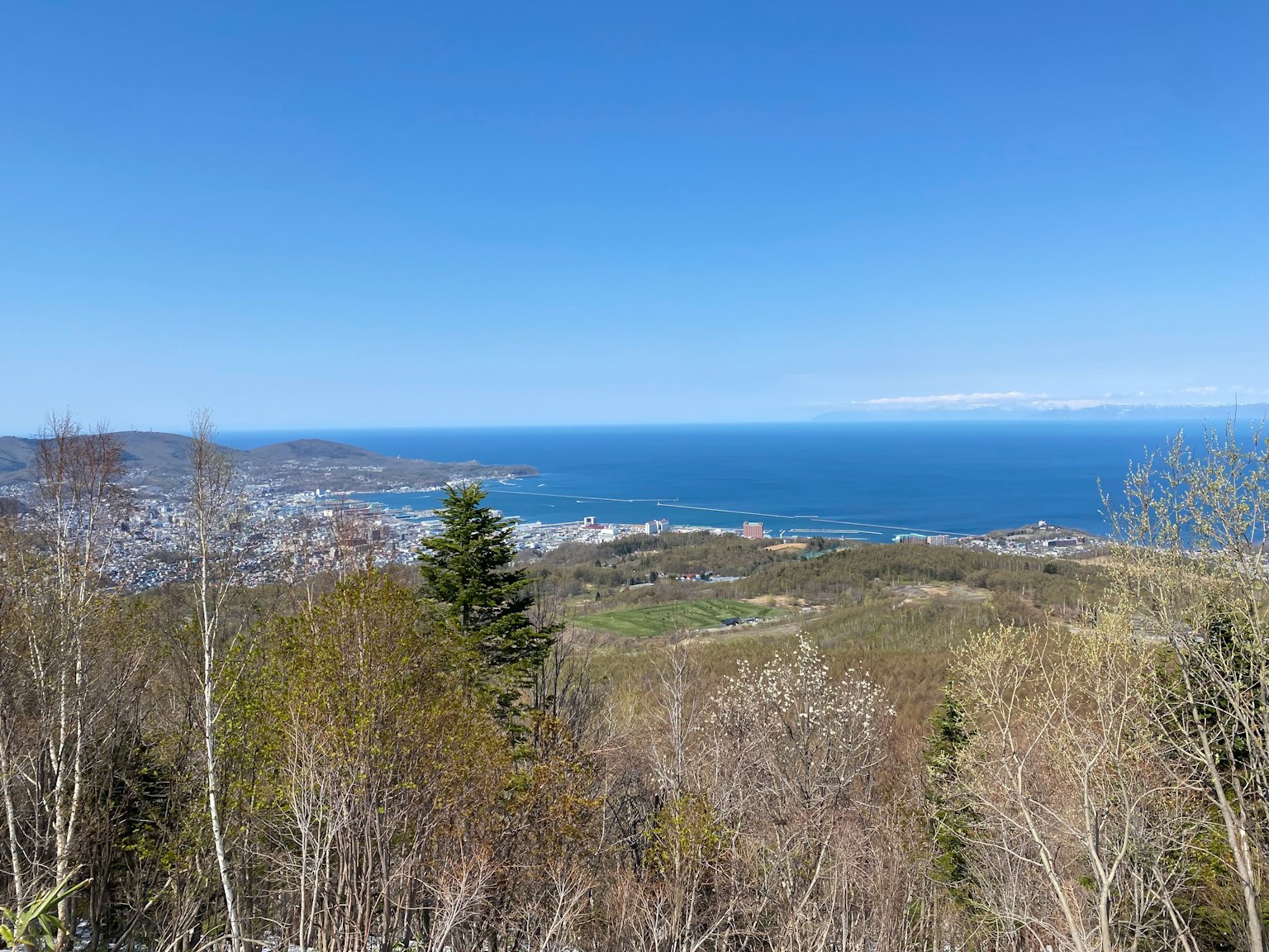 Vista da una montagna che mostra l'oceano blu e le colline verdi