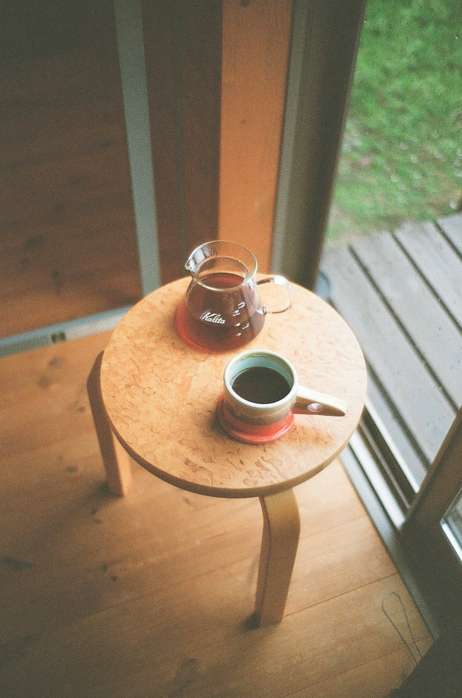 一張木桌上有一個茶壺和一個杯子