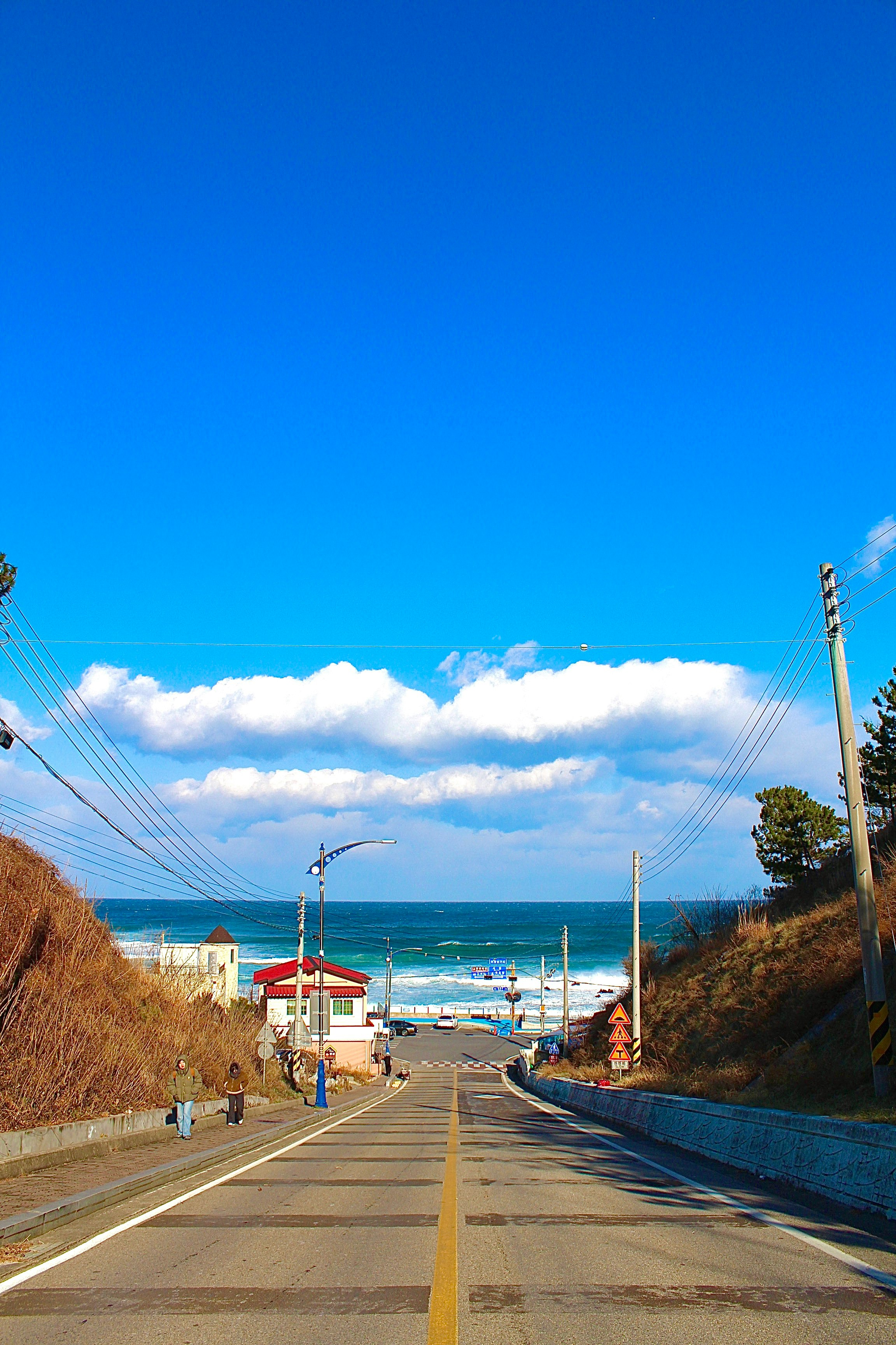 海沿いの坂道を行く道と青い空の風景