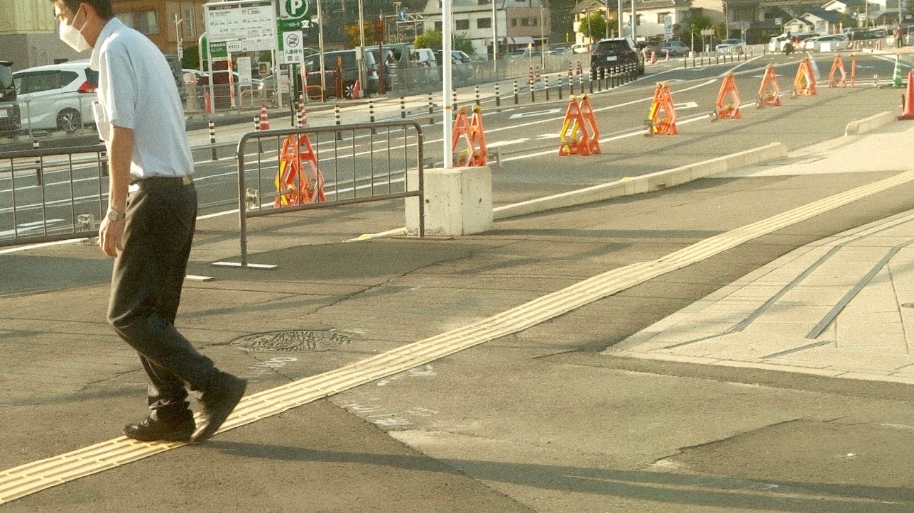 交通規制のある道路で歩行者とコーンが並ぶ風景