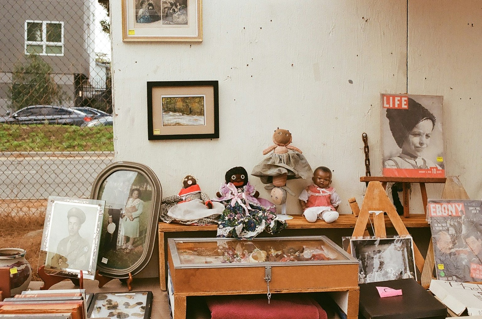 Intérieur d'une boutique d'antiquités avec des poupées vintage et des photos encadrées