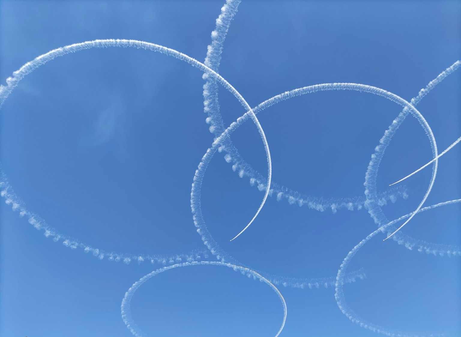 Weiße Rauchspuren, die Kreise in einem klaren blauen Himmel bilden