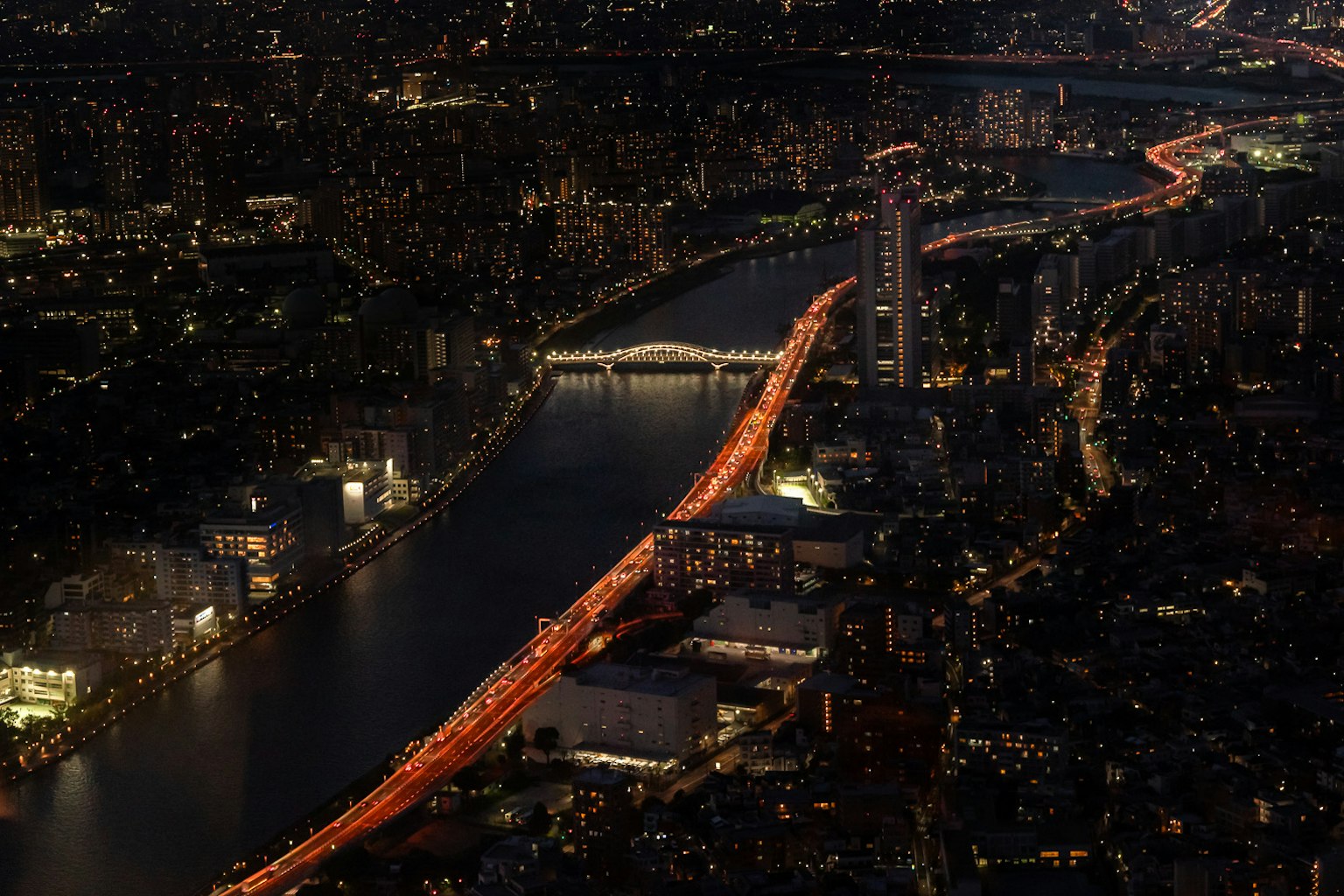 Stupenda vista notturna di Tokyo con fiume e luci di auto brillanti