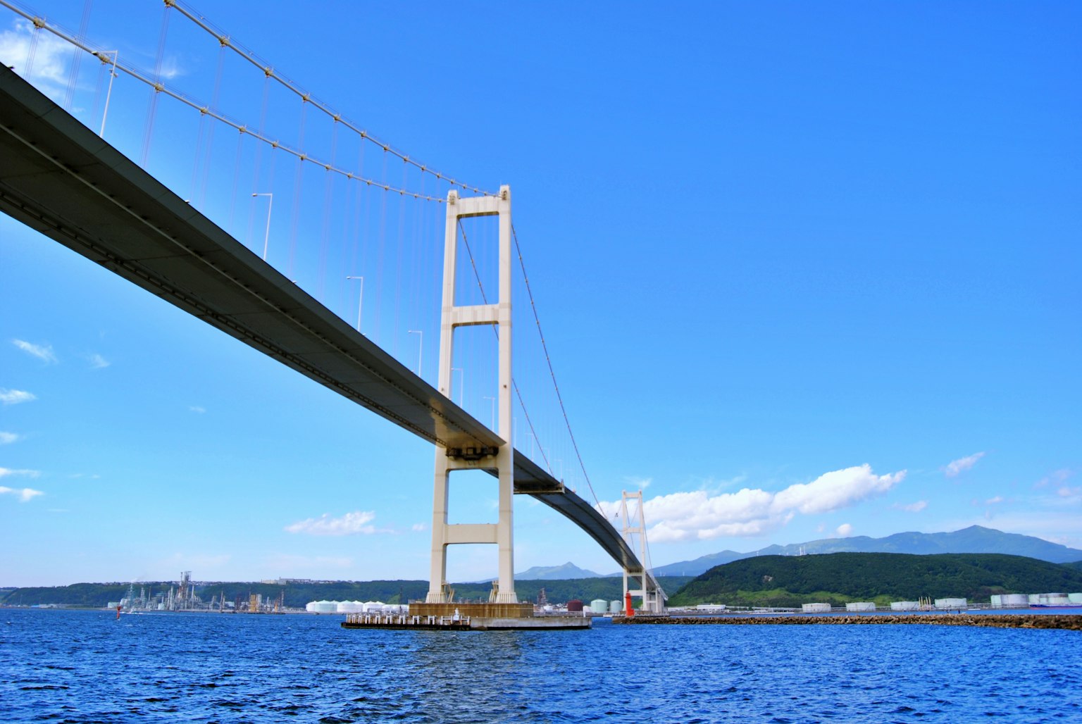 Eine große Brücke, die über Wasser unter einem blauen Himmel spannt