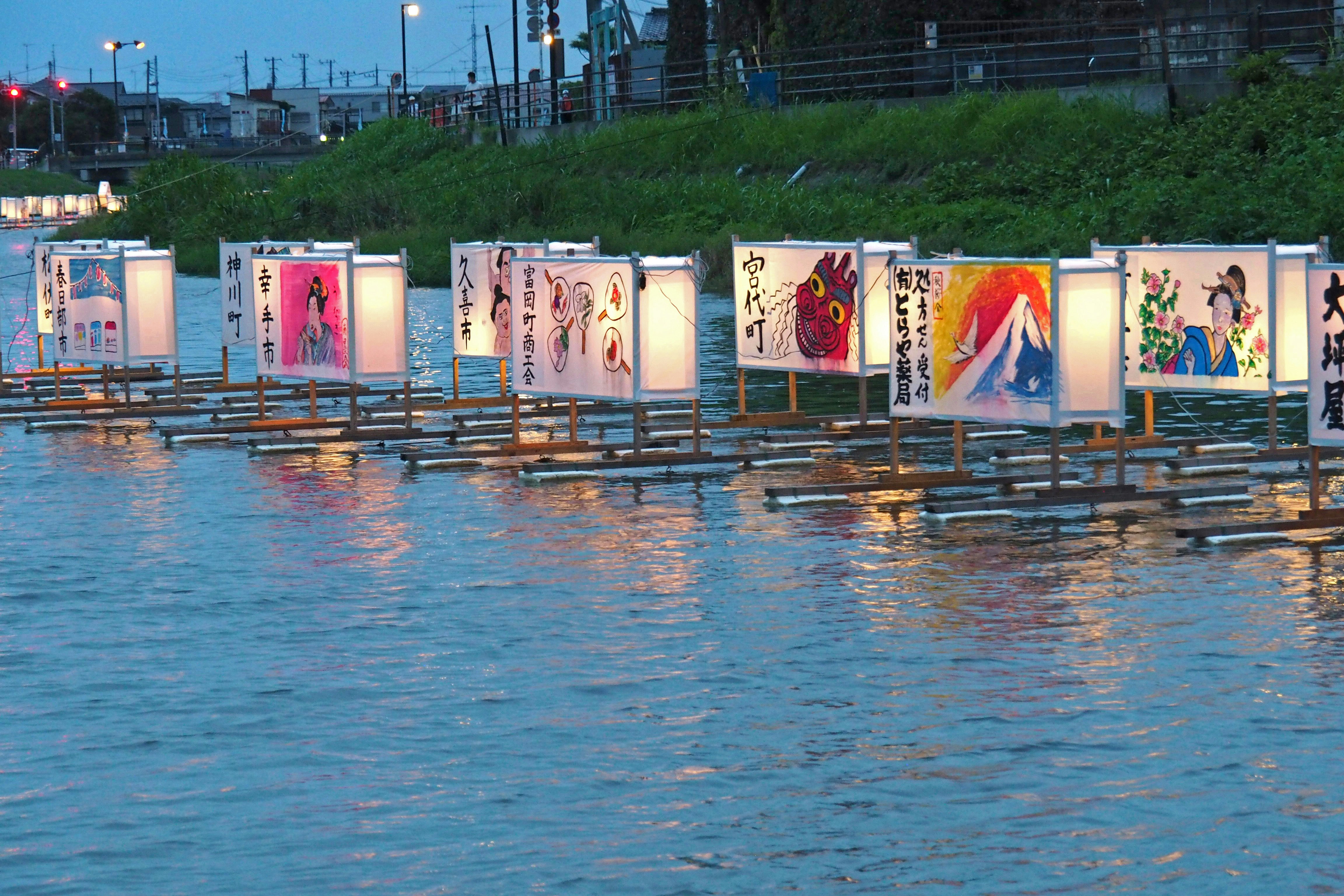 bunte Event-Banner und Plakate entlang eines Flussufers