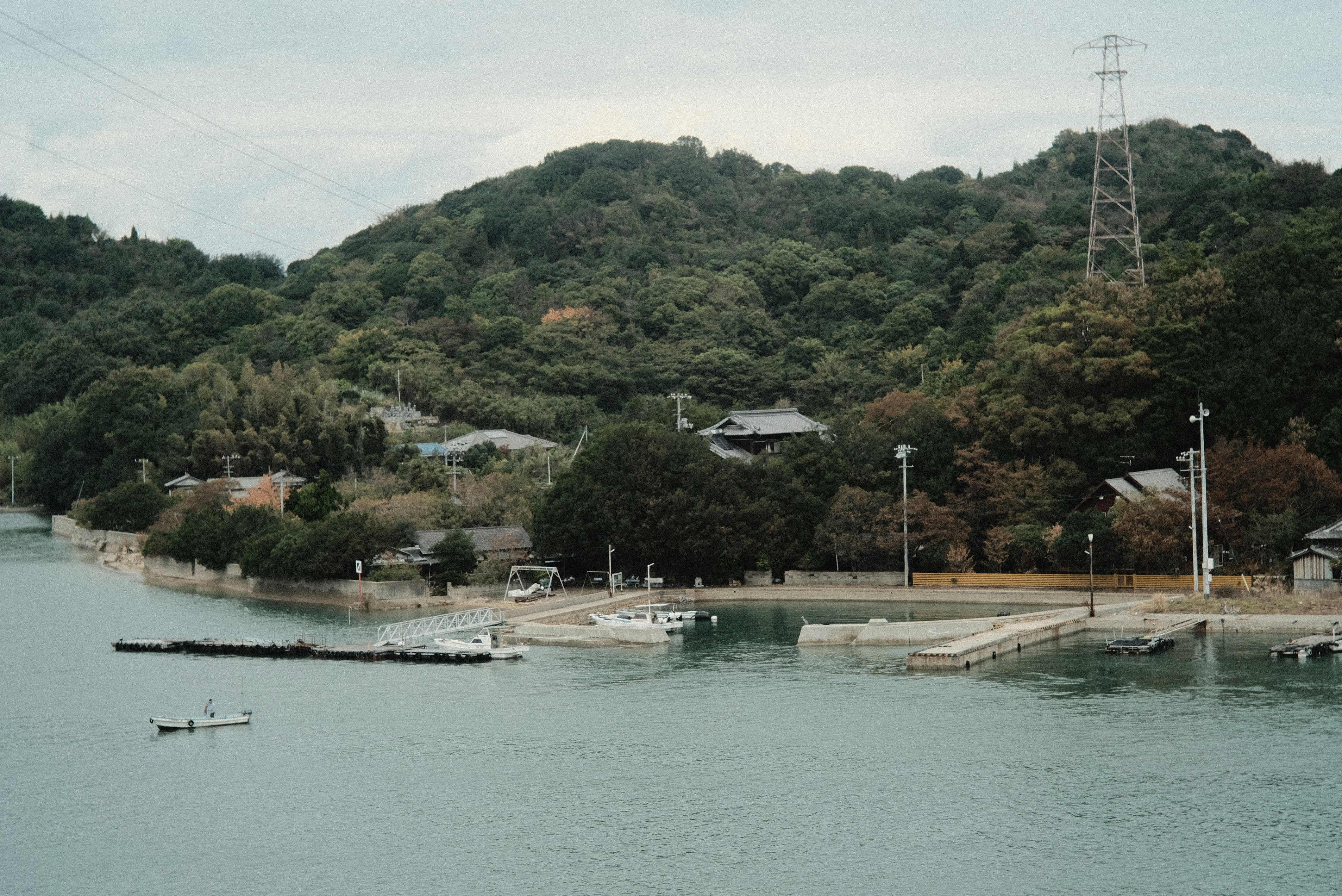 河畔小型港口与堤岸，青绿丘陵景色
