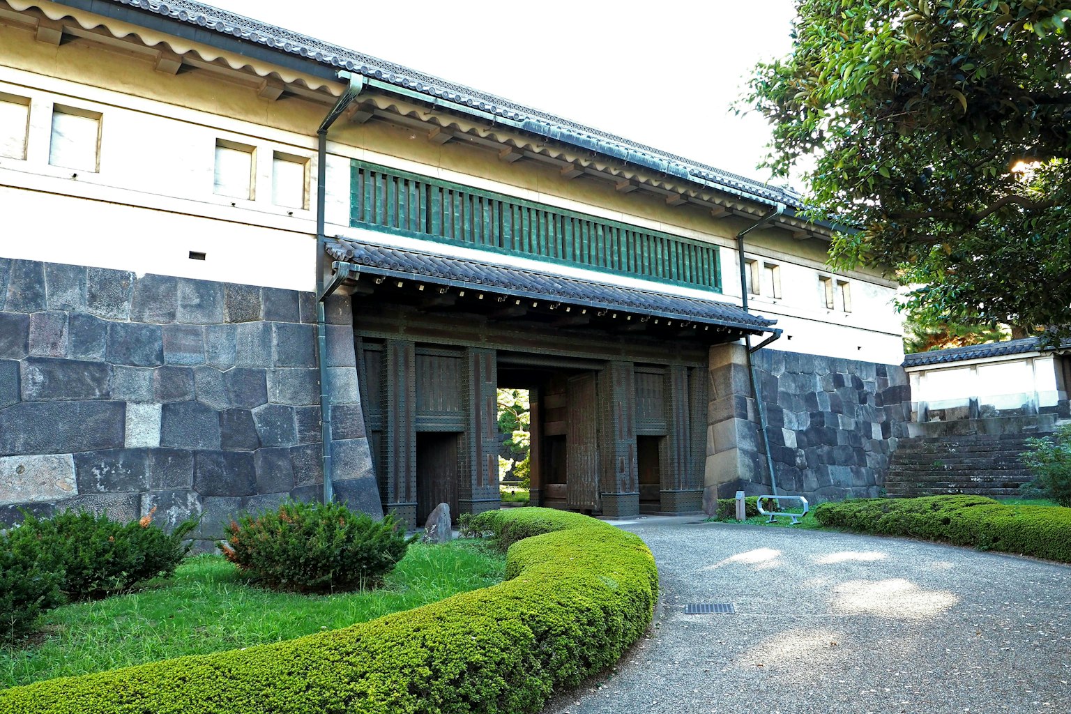 Pintu bangunan tradisional Jepang dengan bingkai jendela hijau dan taman yang dirancang