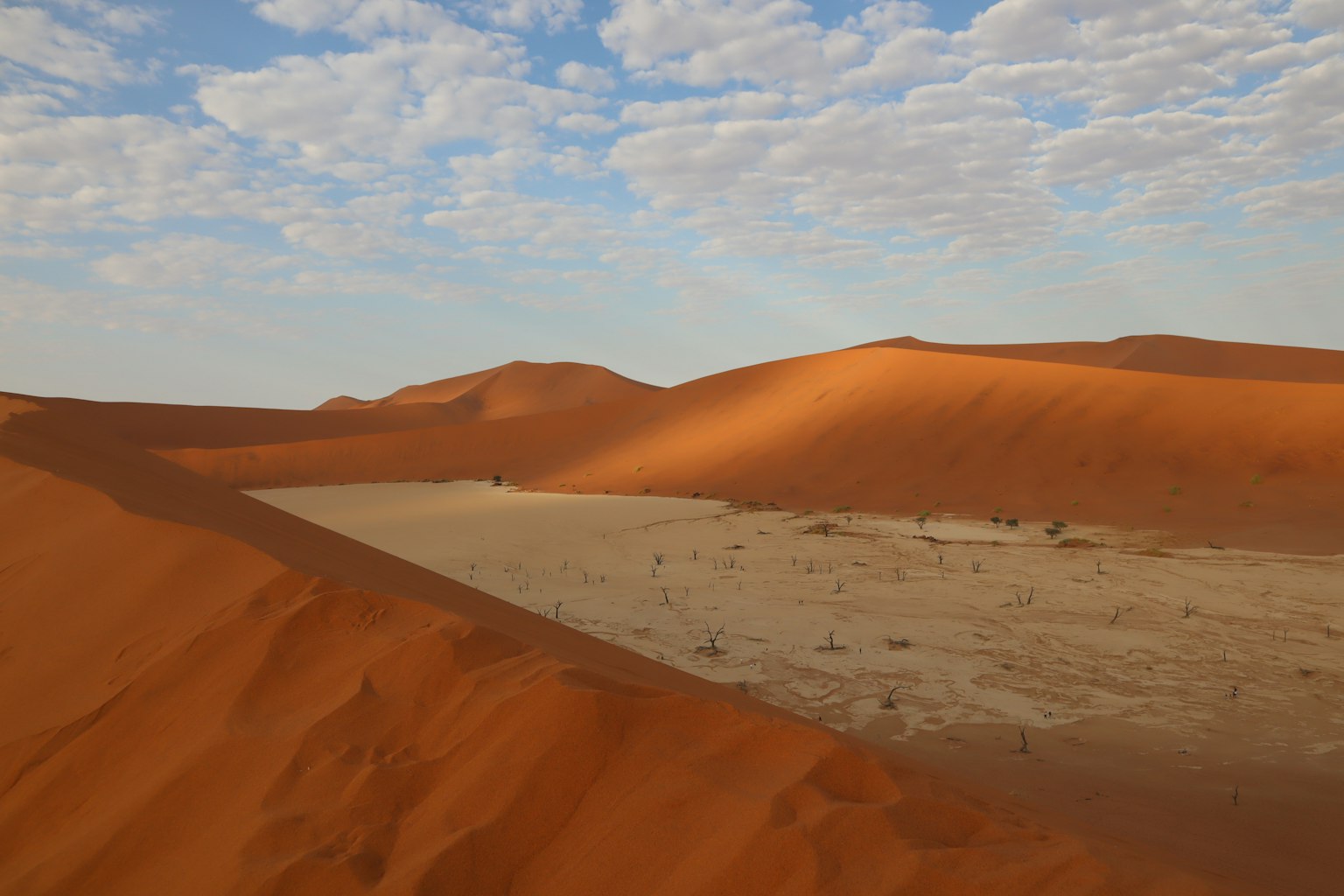 Landscape of sand dunes and blue sky with contrasting red and white sand