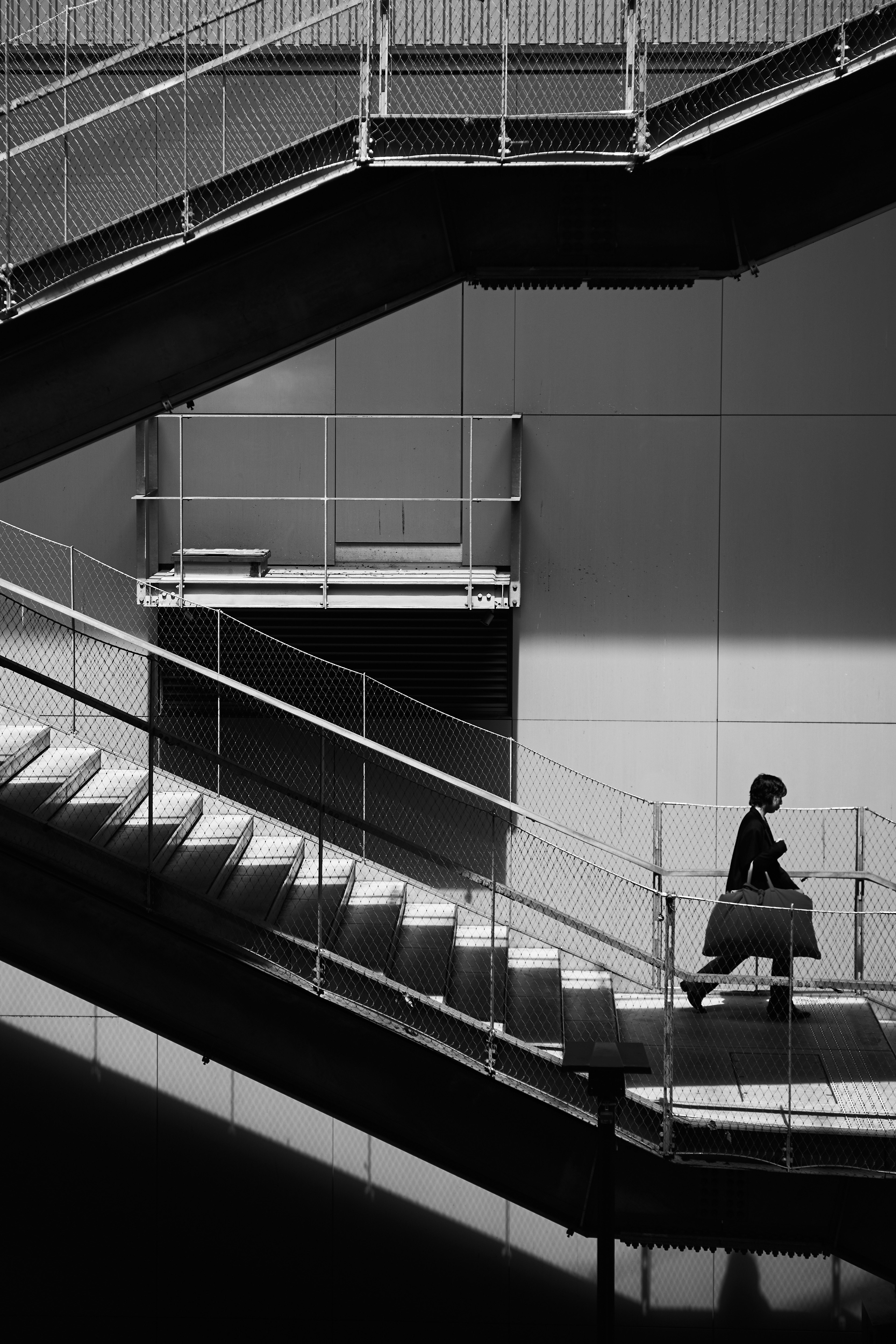 a person walking inside a building with staircases and railings