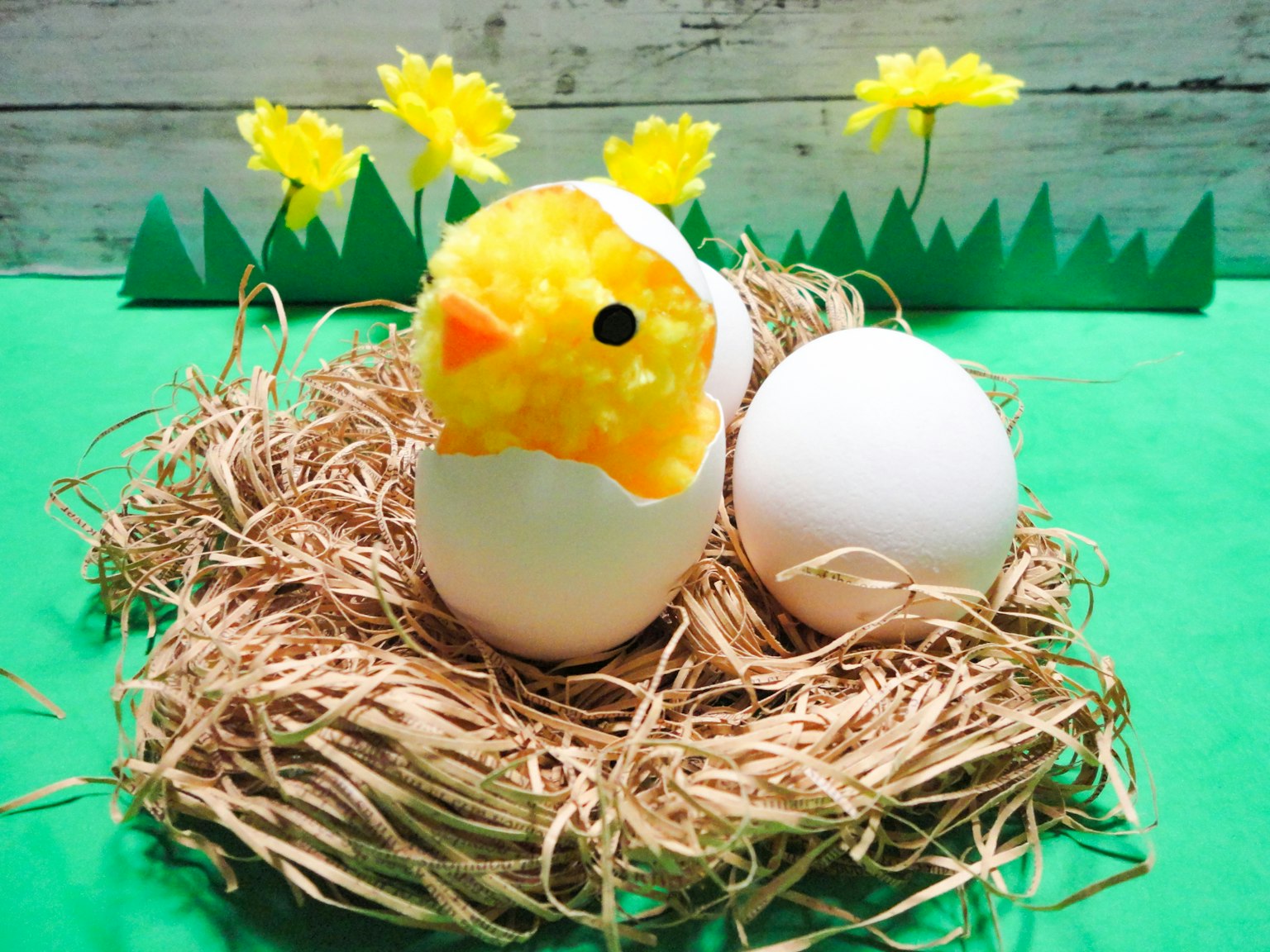 Un pollito amarillo asomándose de una cáscara de huevo en una escena primaveral colorida