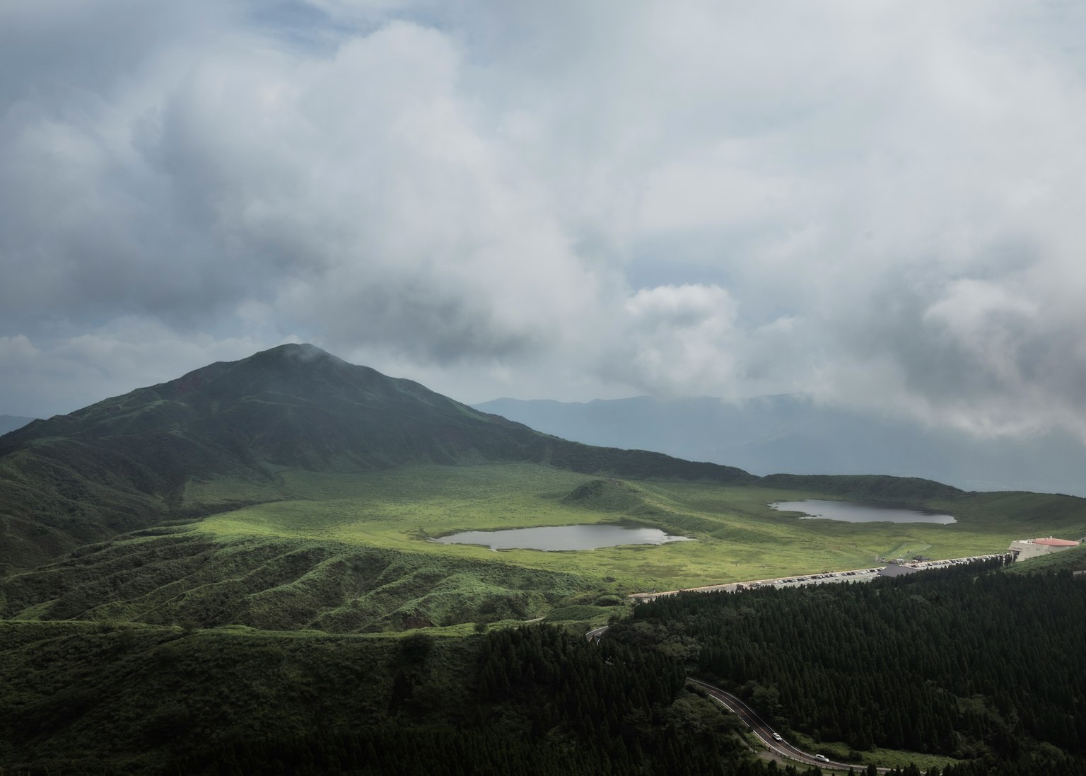 Üppige grüne Berglandschaft mit bewölktem Himmel