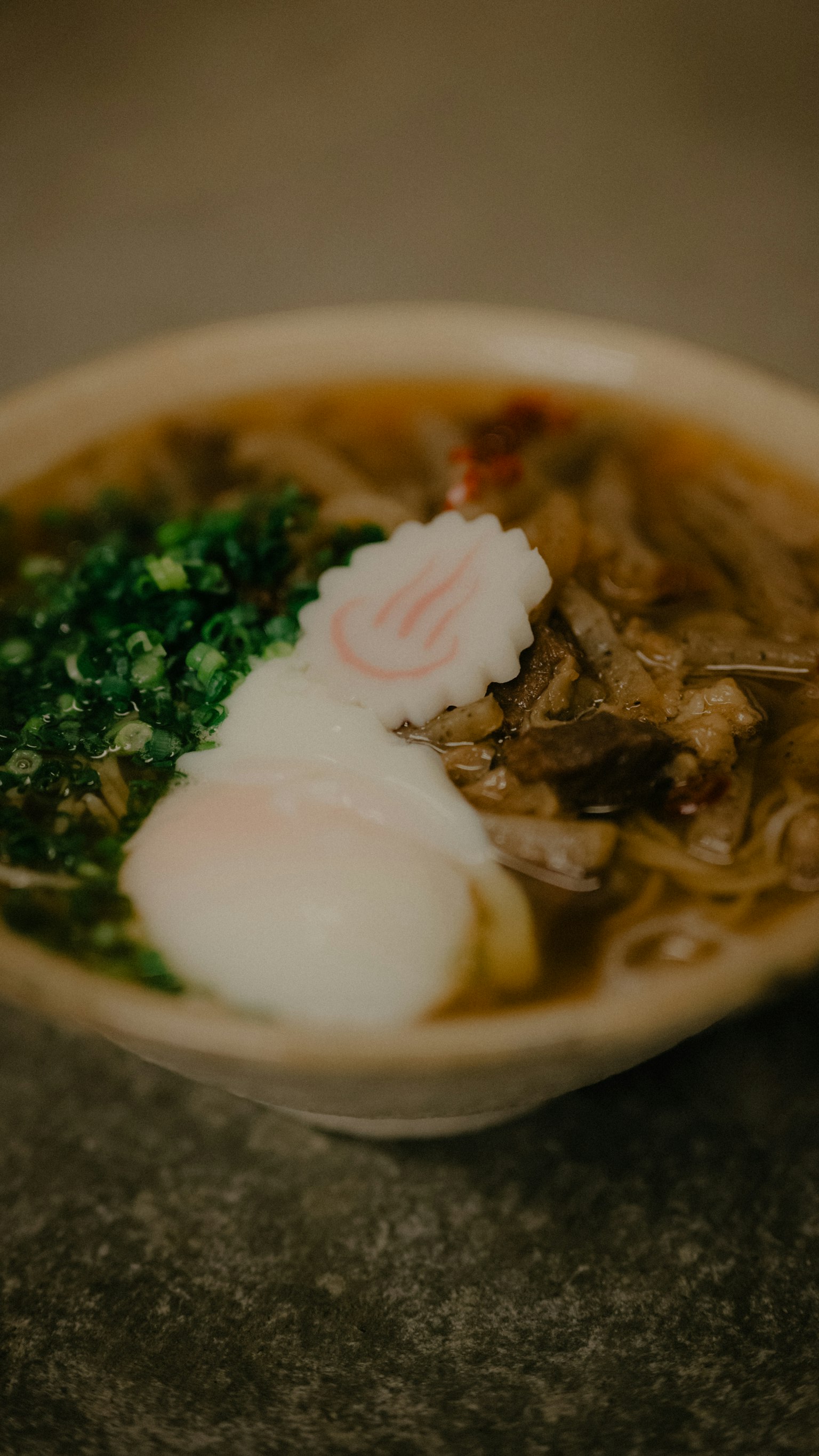 Mangkuk ramen dengan telur setengah matang dan daun bawang