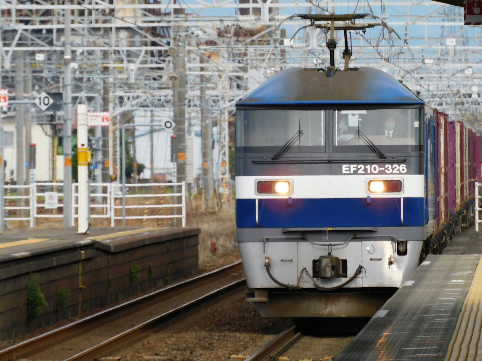 Blue and white EF210-236 locomotive pulling a freight train