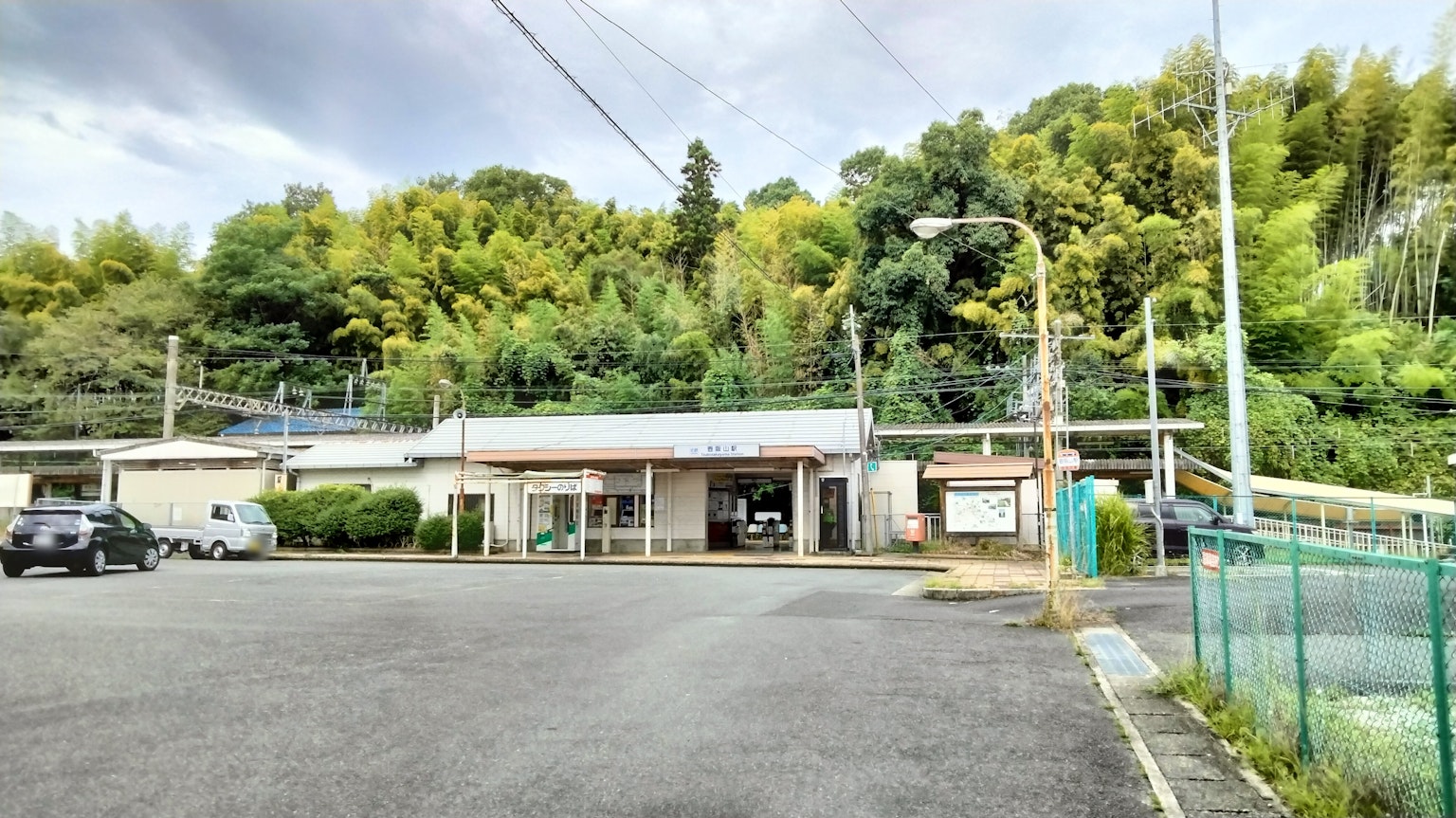 Quiet rural train station with lush green background
