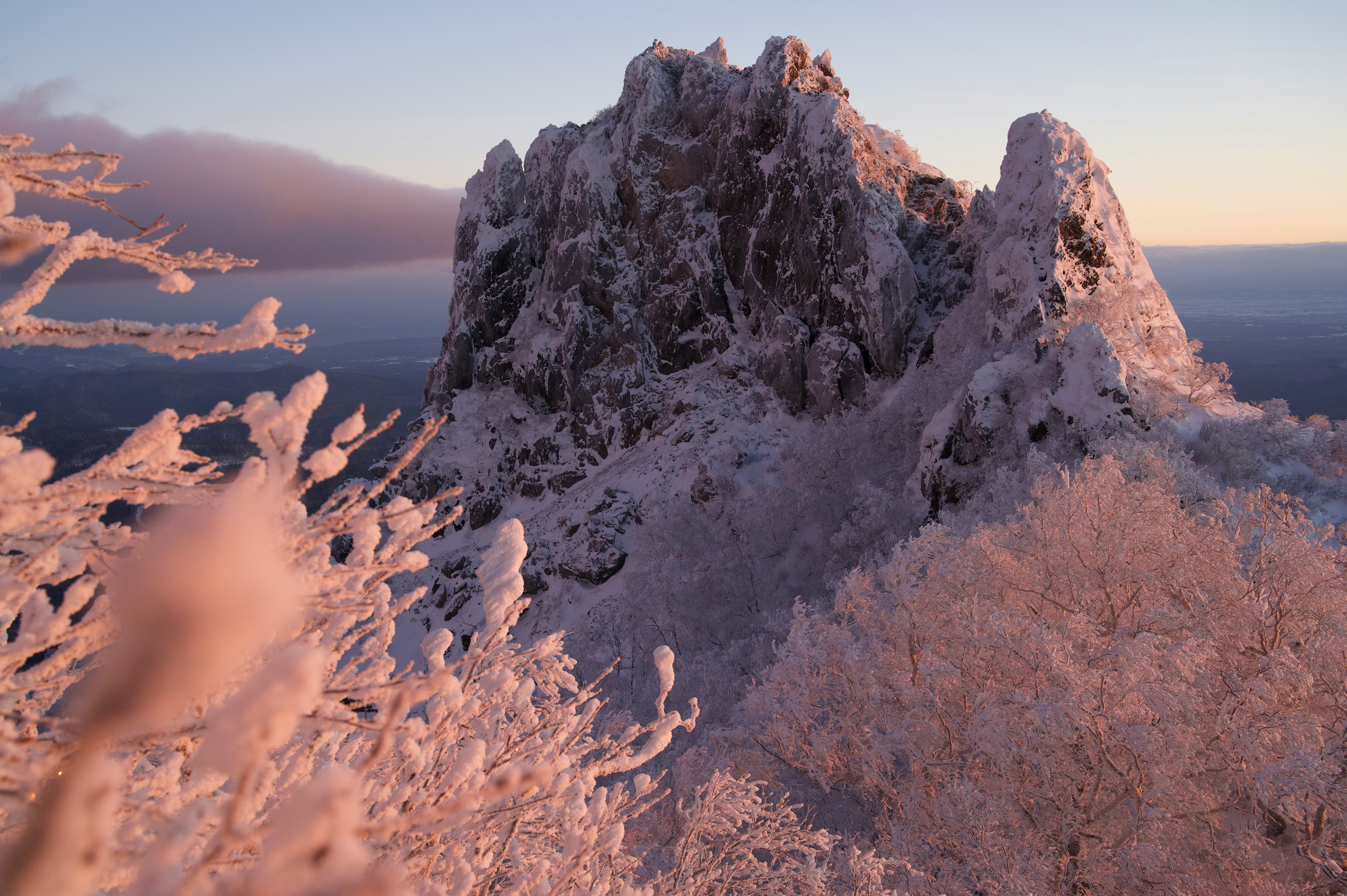 夕暮れの雪をまとった山頂と稜線の眺め