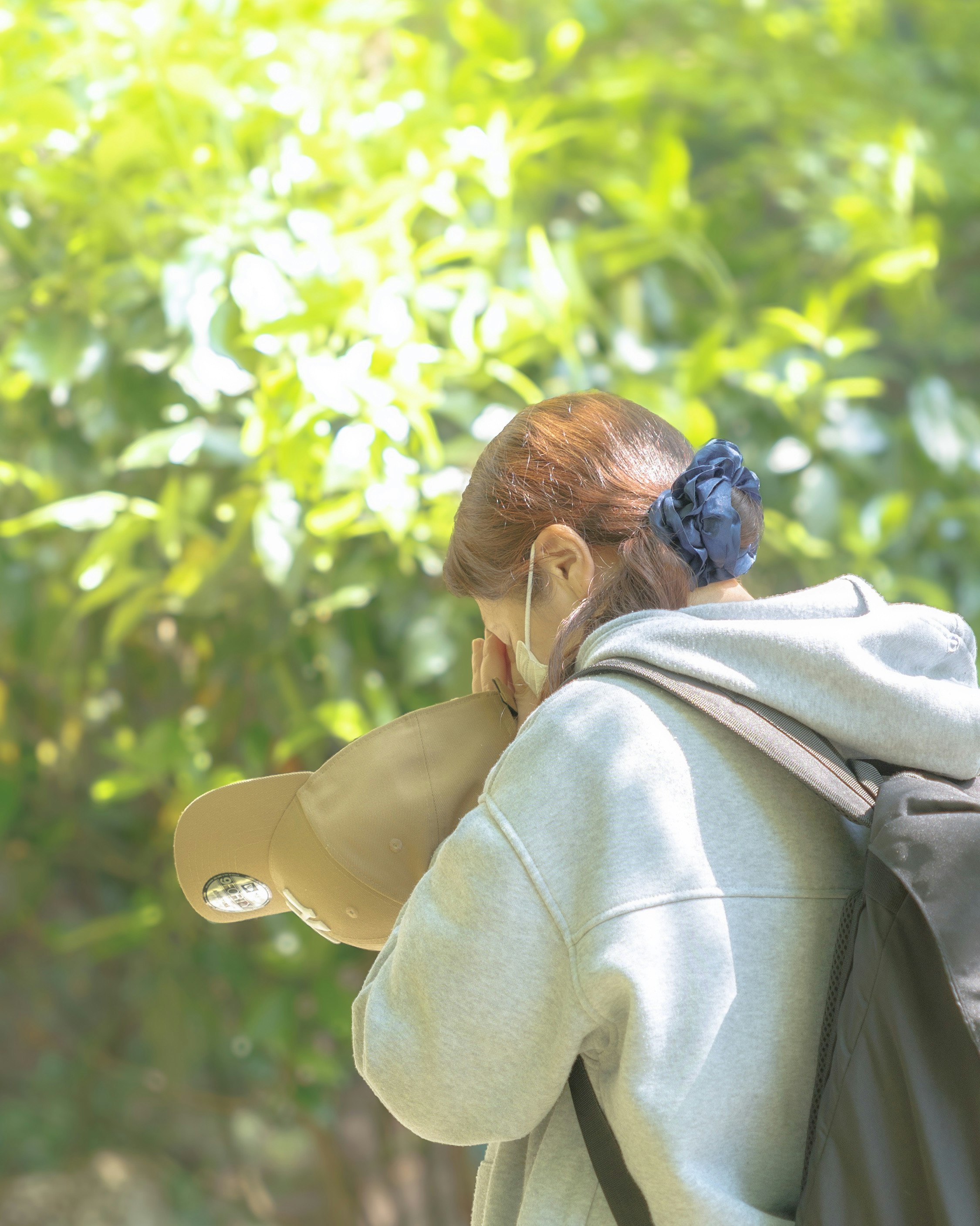 Genitore che tiene un bambino da dietro in un giardino verde