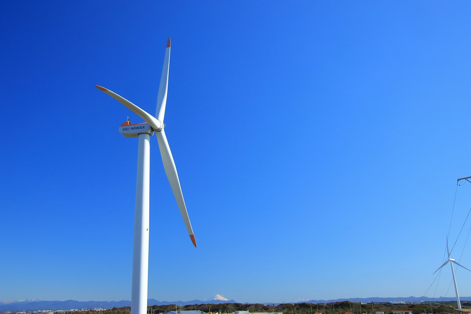 Image of a wind turbine standing under a blue sky