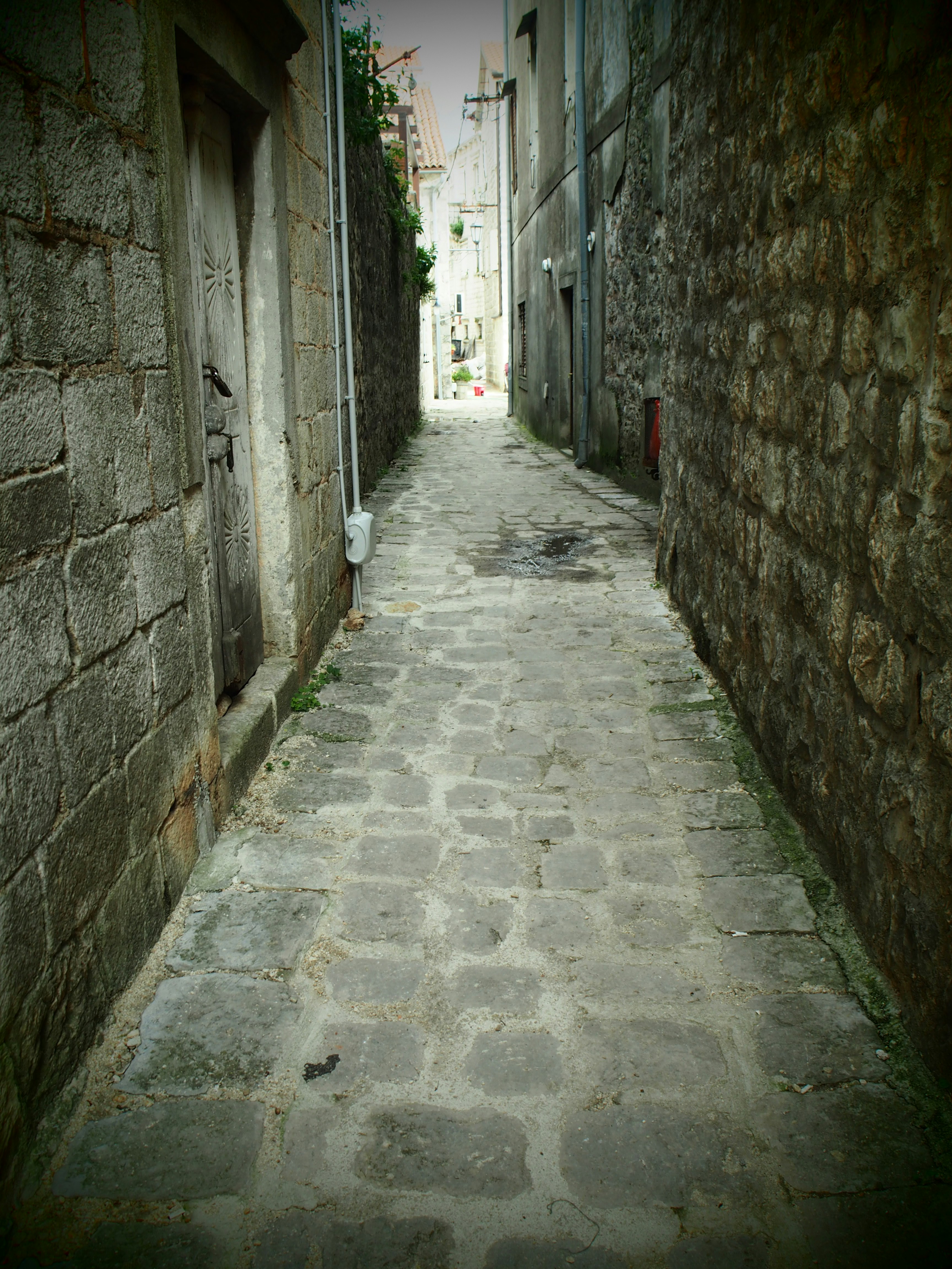 ruelle étroite pavée entre des murs en pierre