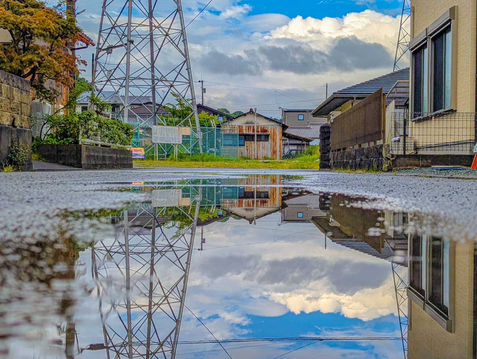 การสะท้อนของท้องฟ้าและเมฆในแอ่งน้ำพร้อมเสาไฟฟ้า