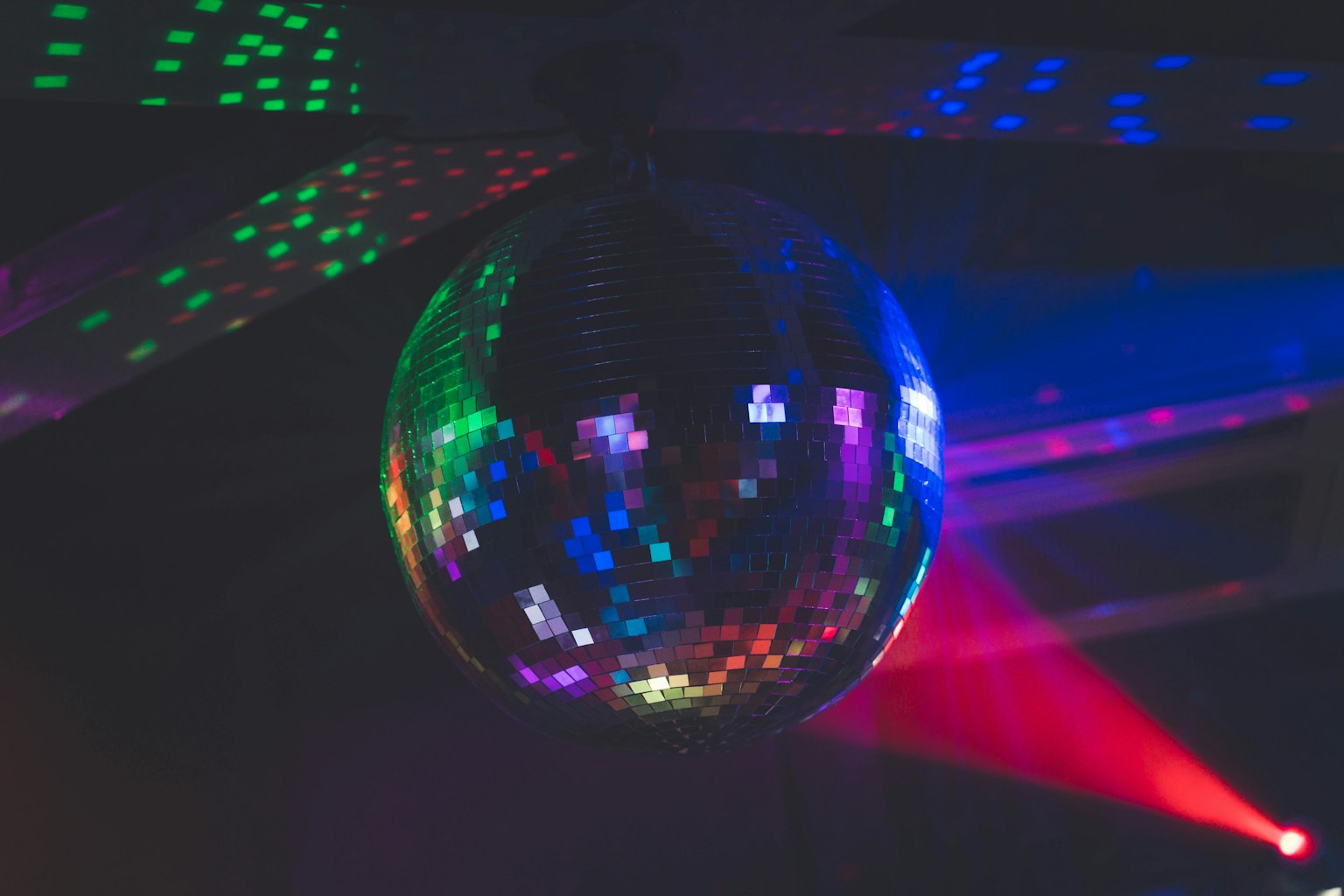 Une boule à facettes reflétant des lumières colorées suspendue au plafond