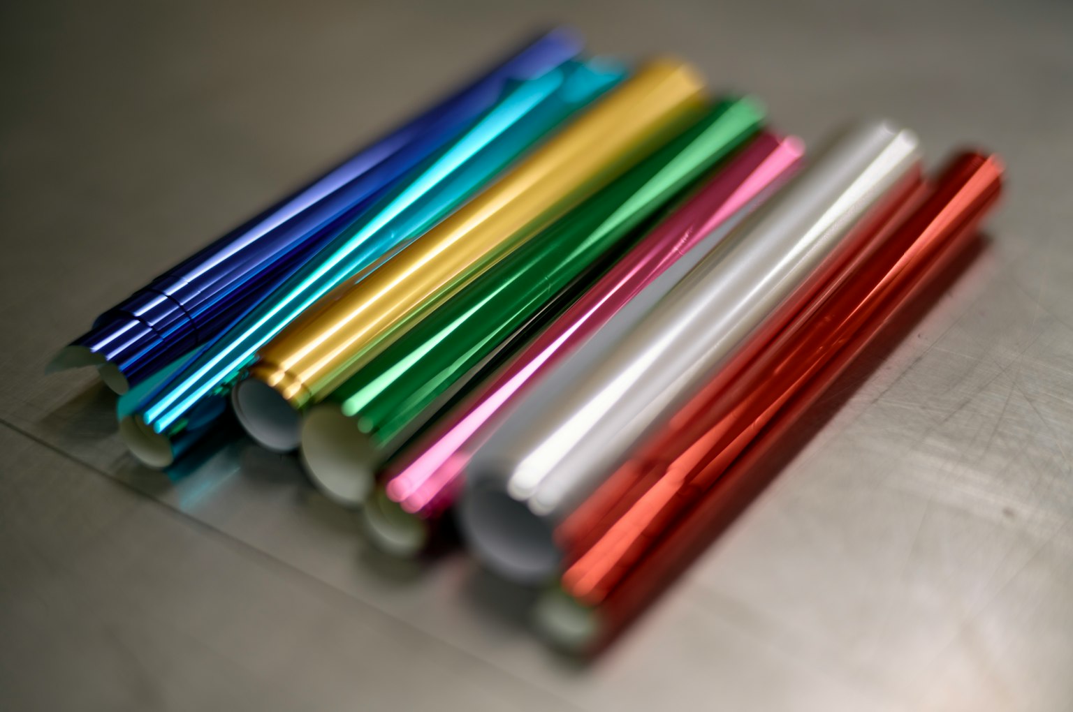 Gulung aluminium berwarna yang diatur di permukaan logam